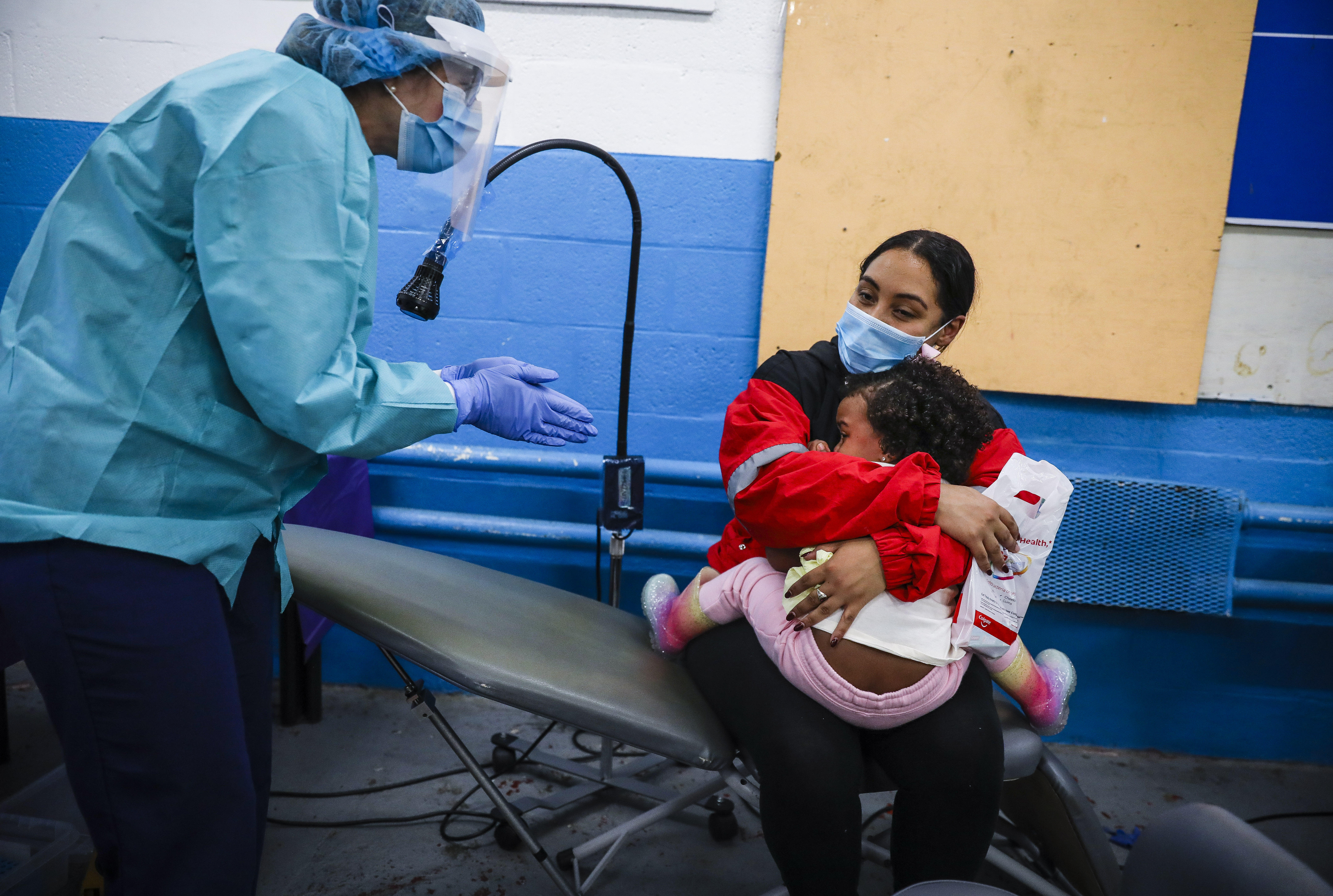 ForsythKids dental hygienist Roquel Norris clapped for 2-year-old Emma Alvarez after completing her dental examination with her mother, Grace Duran.