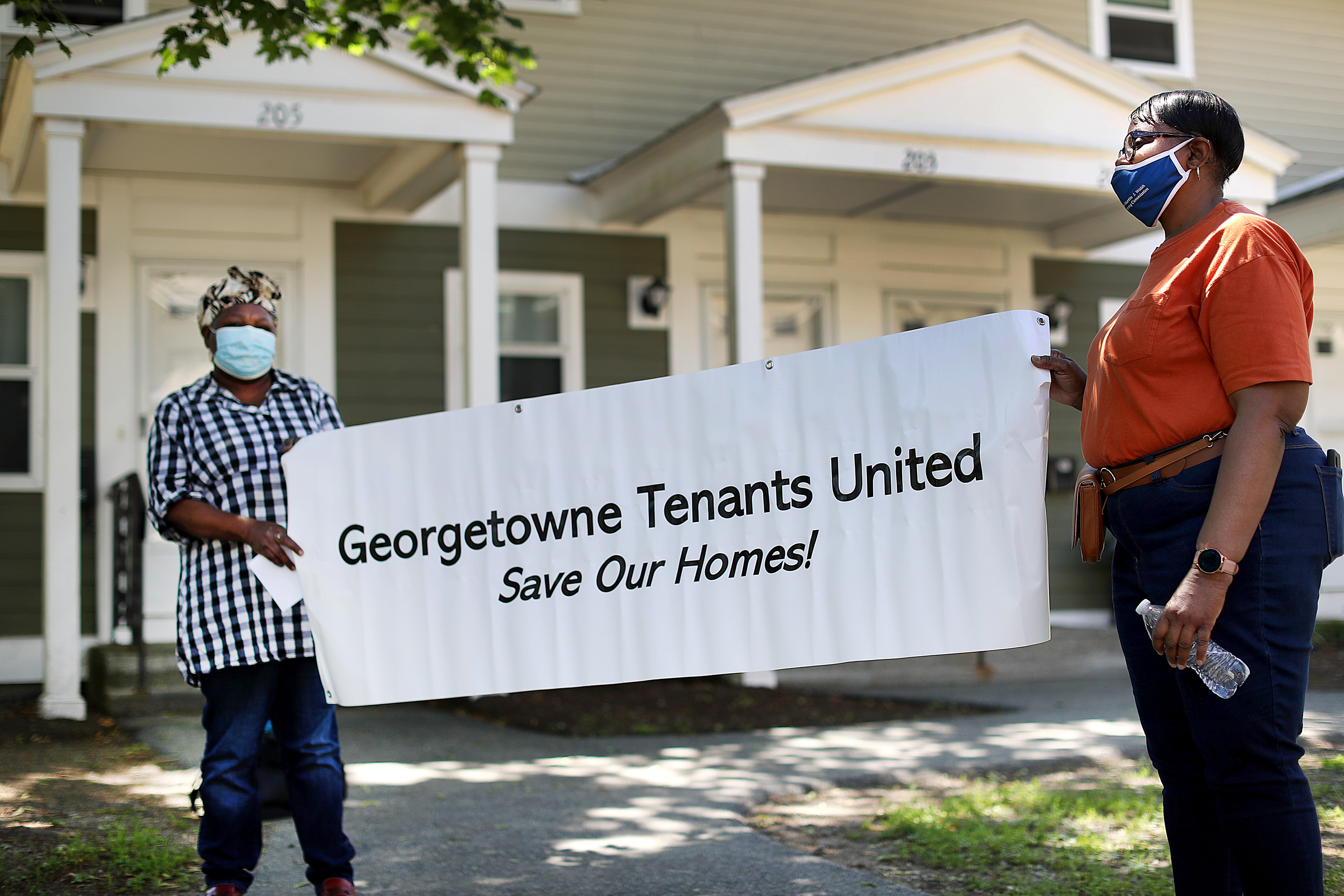 Anelore Jacques,(left) a resident for 21 years at the Georgetowne Homes is upset about the lack of repairs by the management of the complex. She holds a sign with resident Marcella Jones during a rally at the complex to bring attention to the living conditions and evictions.