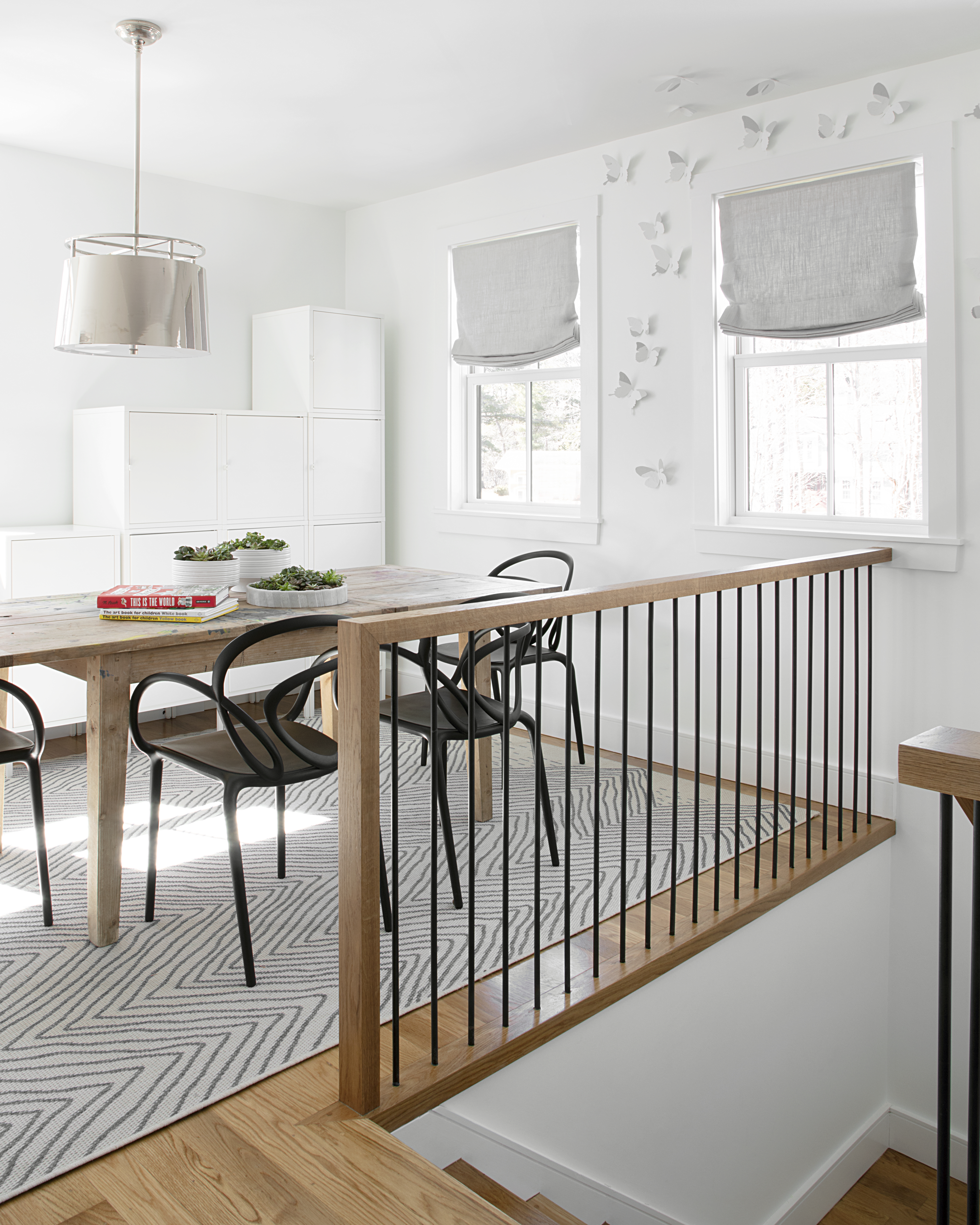 A table and plastic chairs, an indoor/outdoor rug, and IKEA lockers outfit an activity area. “We wanted a place where they could leave out ongoing projects,” says homeowner Jacquelyn Burke. “My daughter spent all her free time up there when school shut down.”