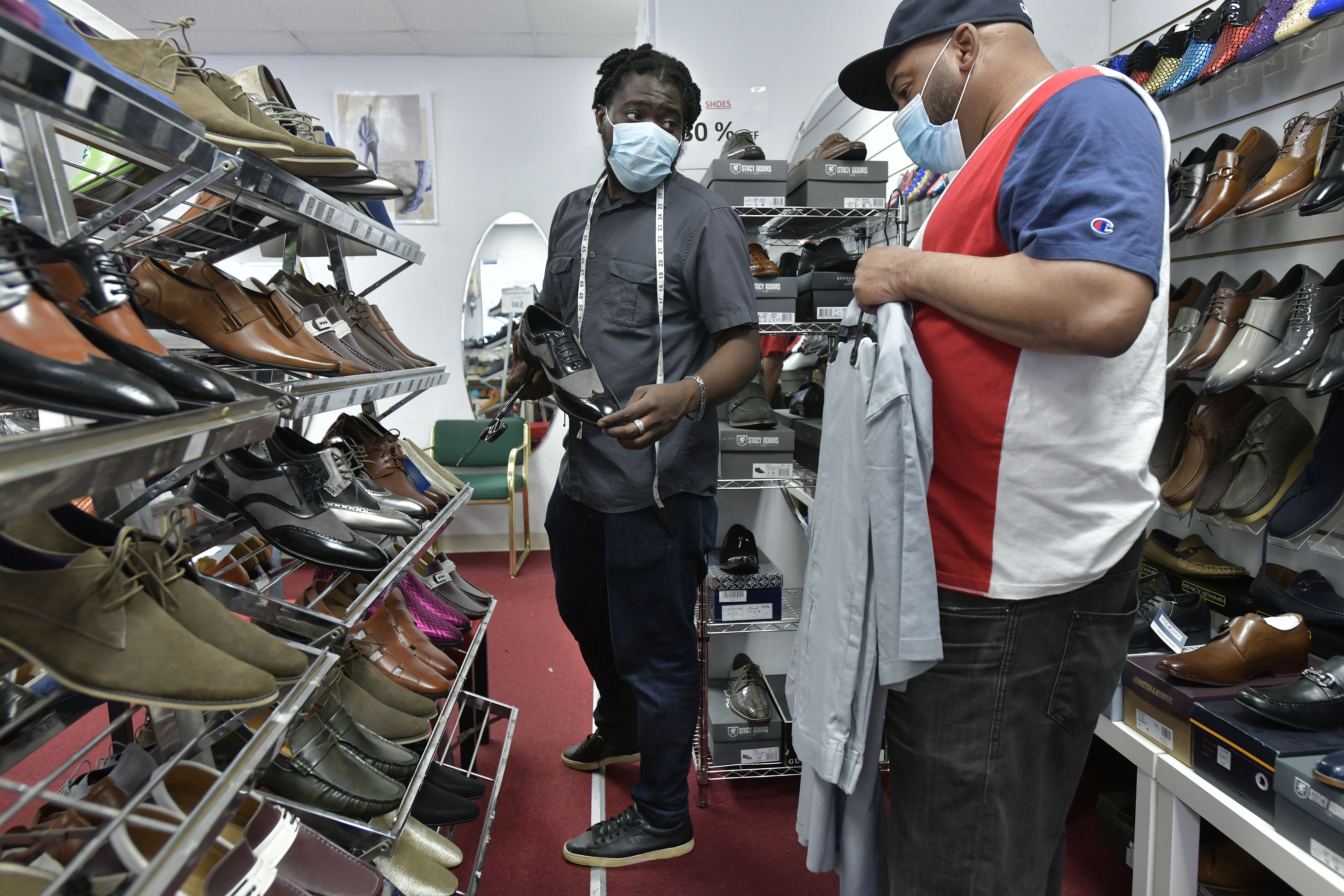 Goddy Joint (left), manager of Porta Classica a men's clothing and shoe store in Grove Hall, helped Marc Williams of Boston.