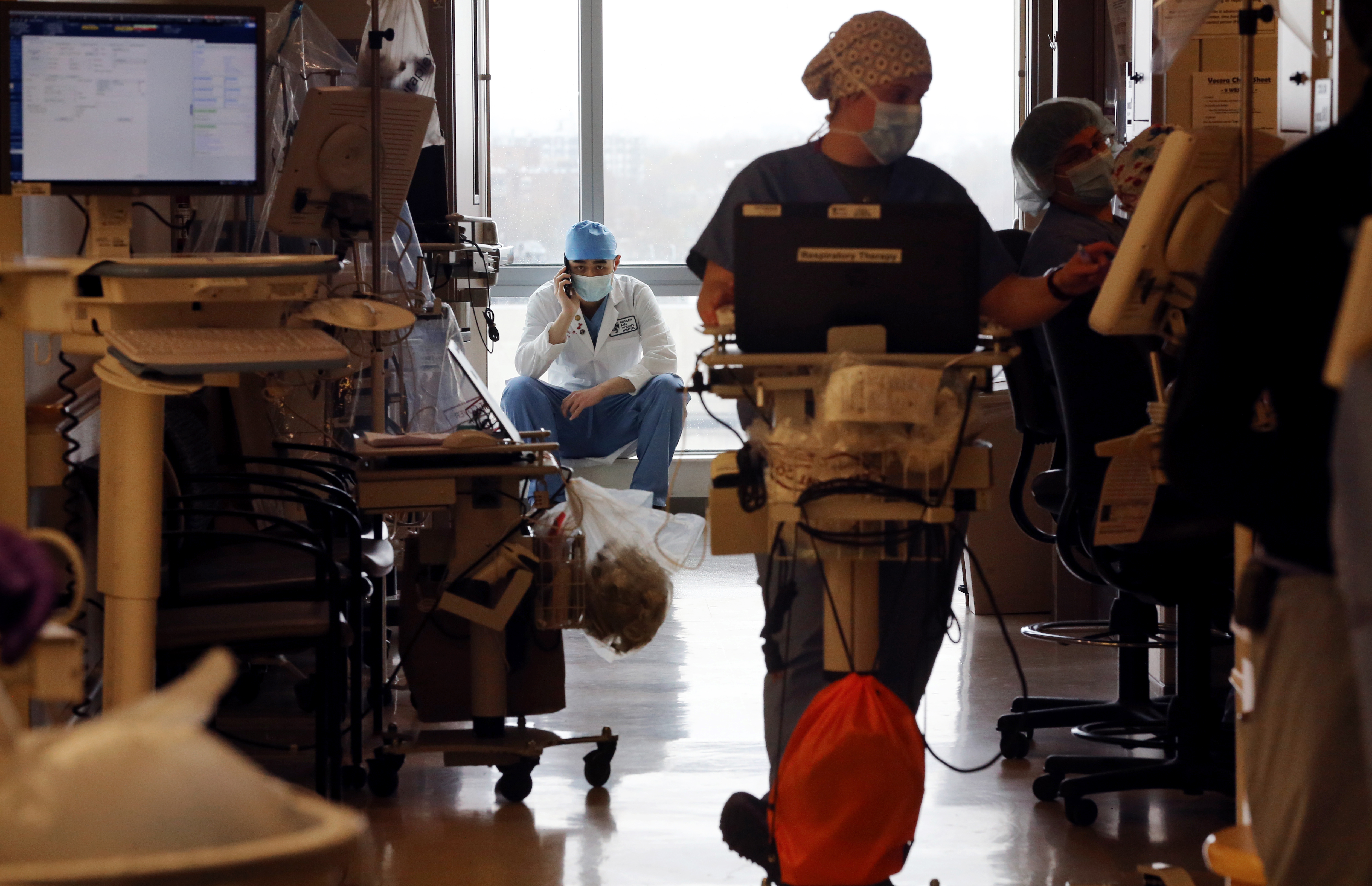 Boston, MA - 4/27/2020: Doctor David Enze Wang talks with a patient's family member on the phone in the Special Pathogen Unit ICU at Brigham and Women's Hospital in Boston, MA on April 27, 2020. The hospital has converted the cardiovascular center into a Covid-19 intensive care unit. (Craig F. Walker/Globe Staff)  section: Metro reporter:  Coronavirus Covid-19 STAT  at Brigham and Women's Hospital in Boston, MA on April 27, 2020.  (Craig F. Walker/Globe Staff)