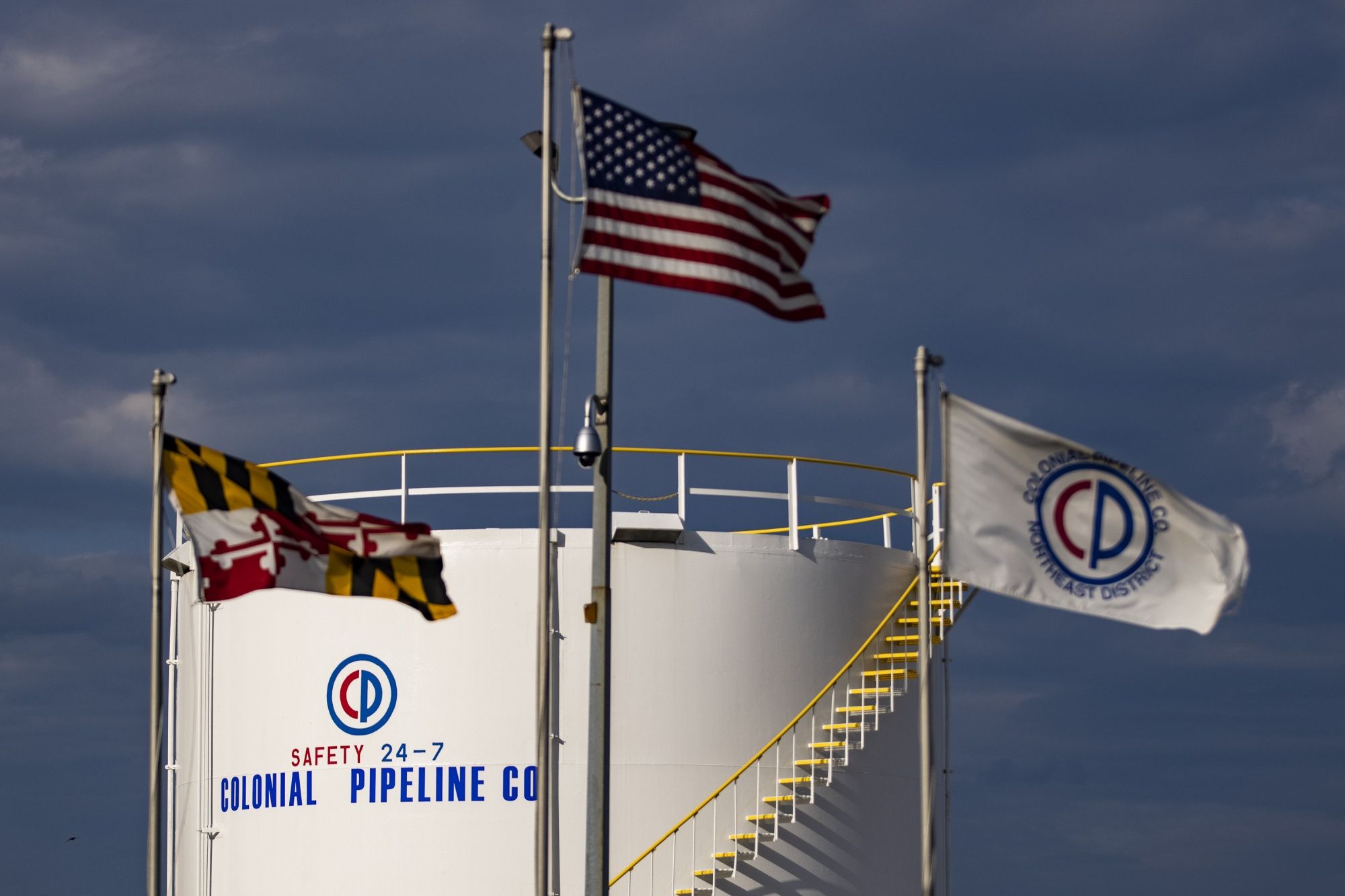 Flags flew in front of a Colonial Pipeline storage tank at a facility in the Port of Baltimore in Baltimore, Md., on Tuesday.
