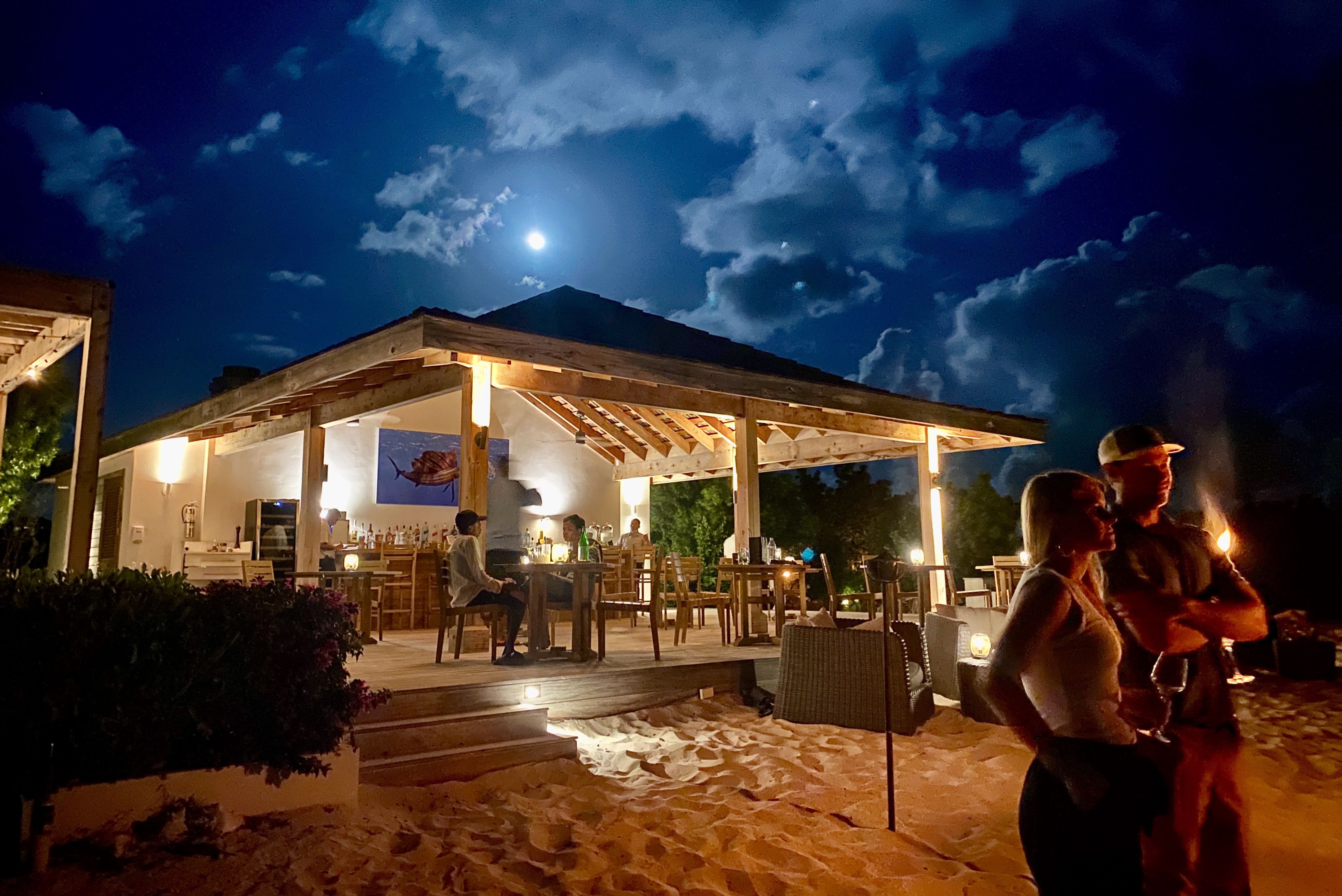 Guests at Sailrock Resort in South Caicos gather to make s'mores at the Cove beach bar.