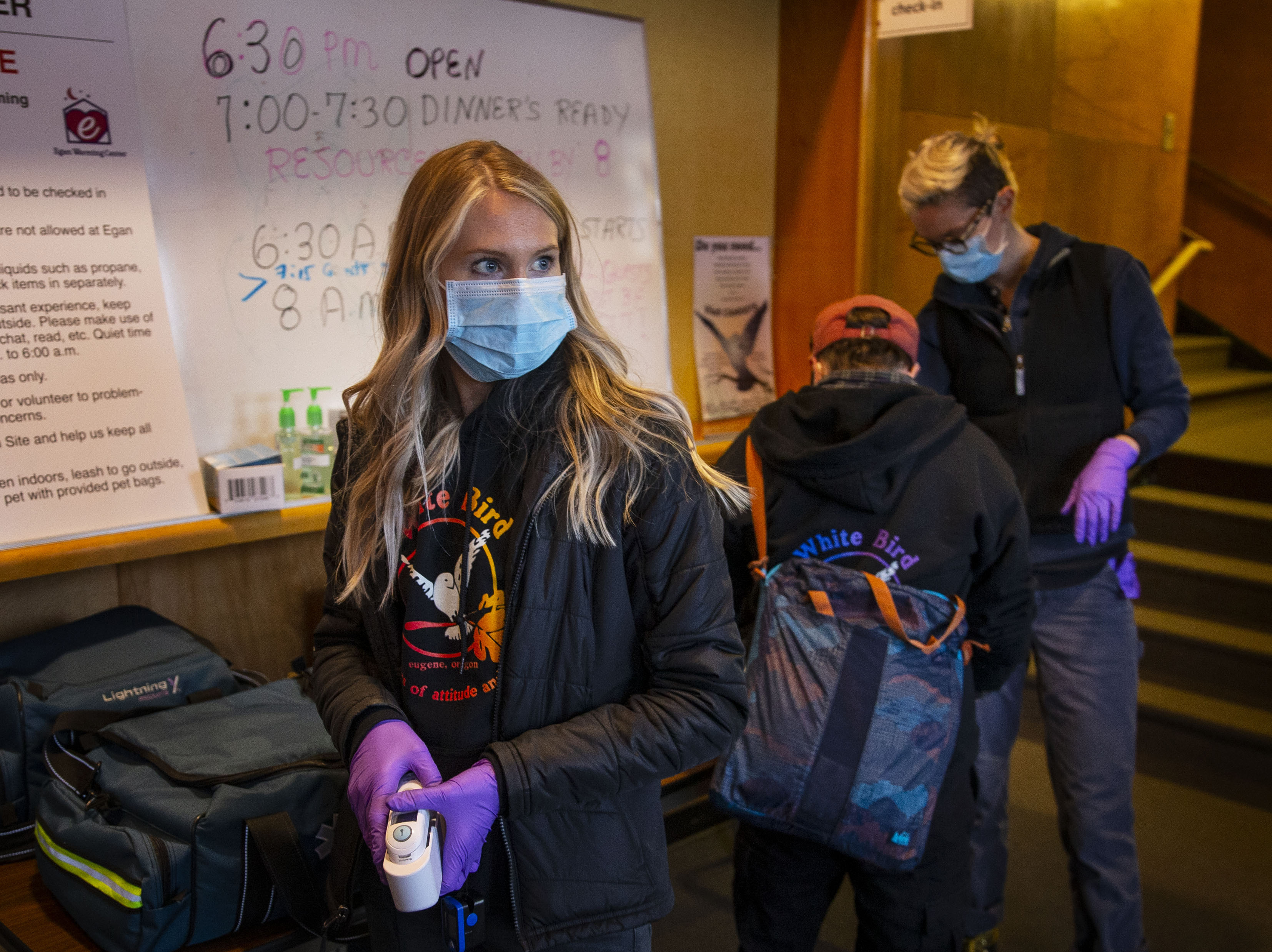 Nurse Celene Eldrich (left) a volunteer nurse for CAHOOTS, waited to screen guests for health concerns at the Egan Warming Center's Springfield, Ore., location.