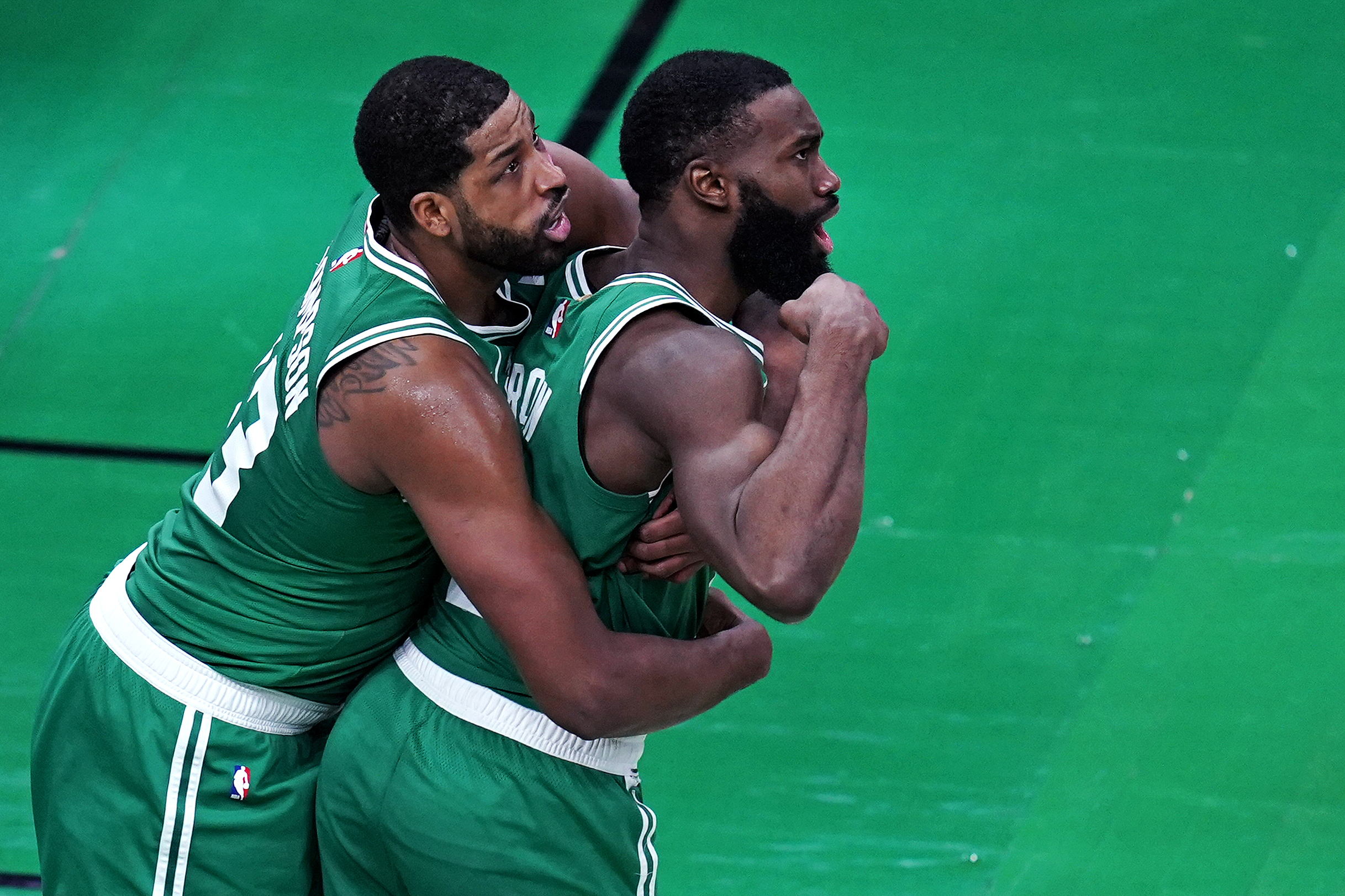 Jaylen Brown flexes after scoring a basket while being embraced by Tristan Thompson during the first half of Wednesday's game.