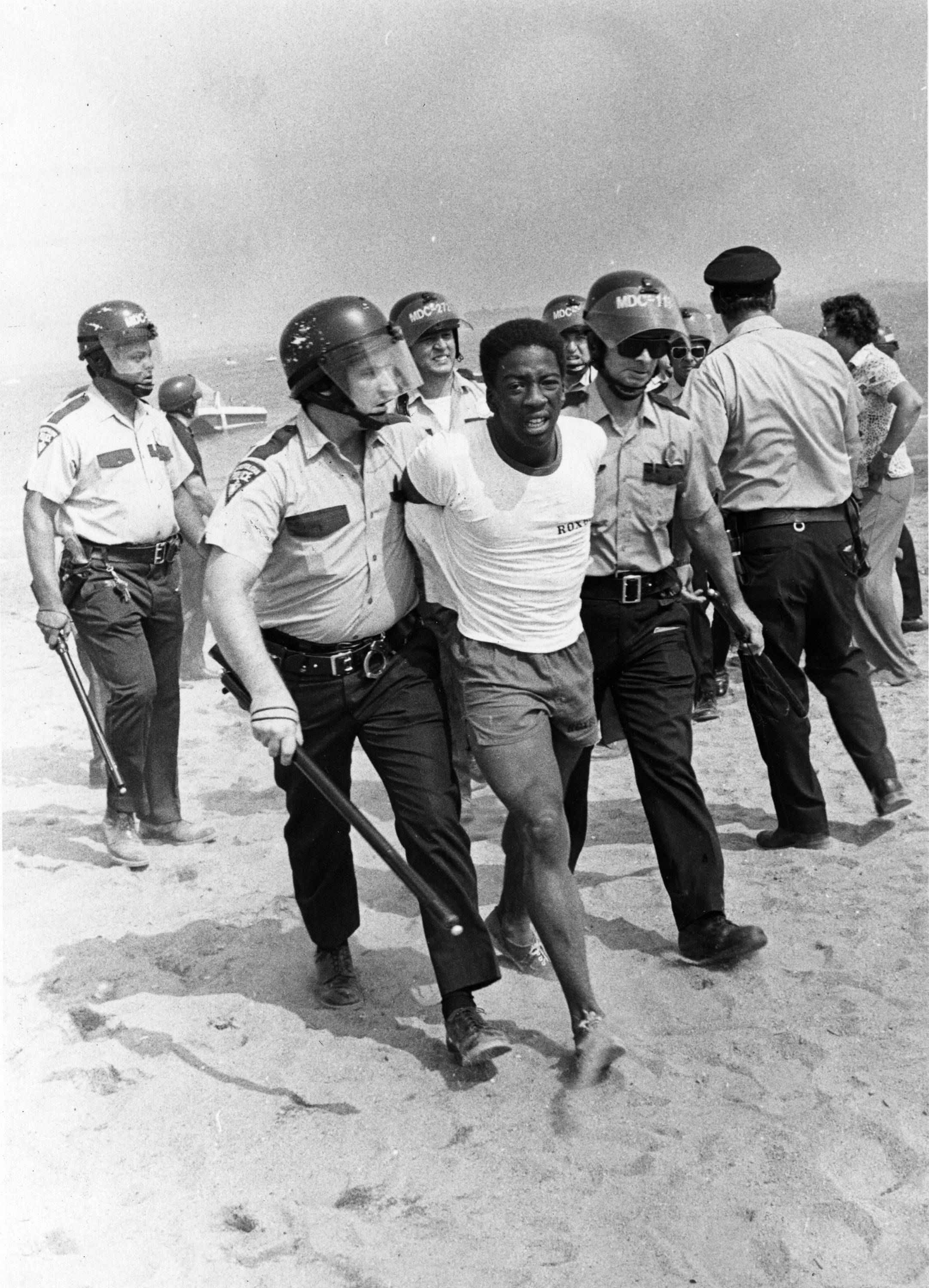 Police walk a demonstrator from the Carson Beach sit-in on August 10, 1975.