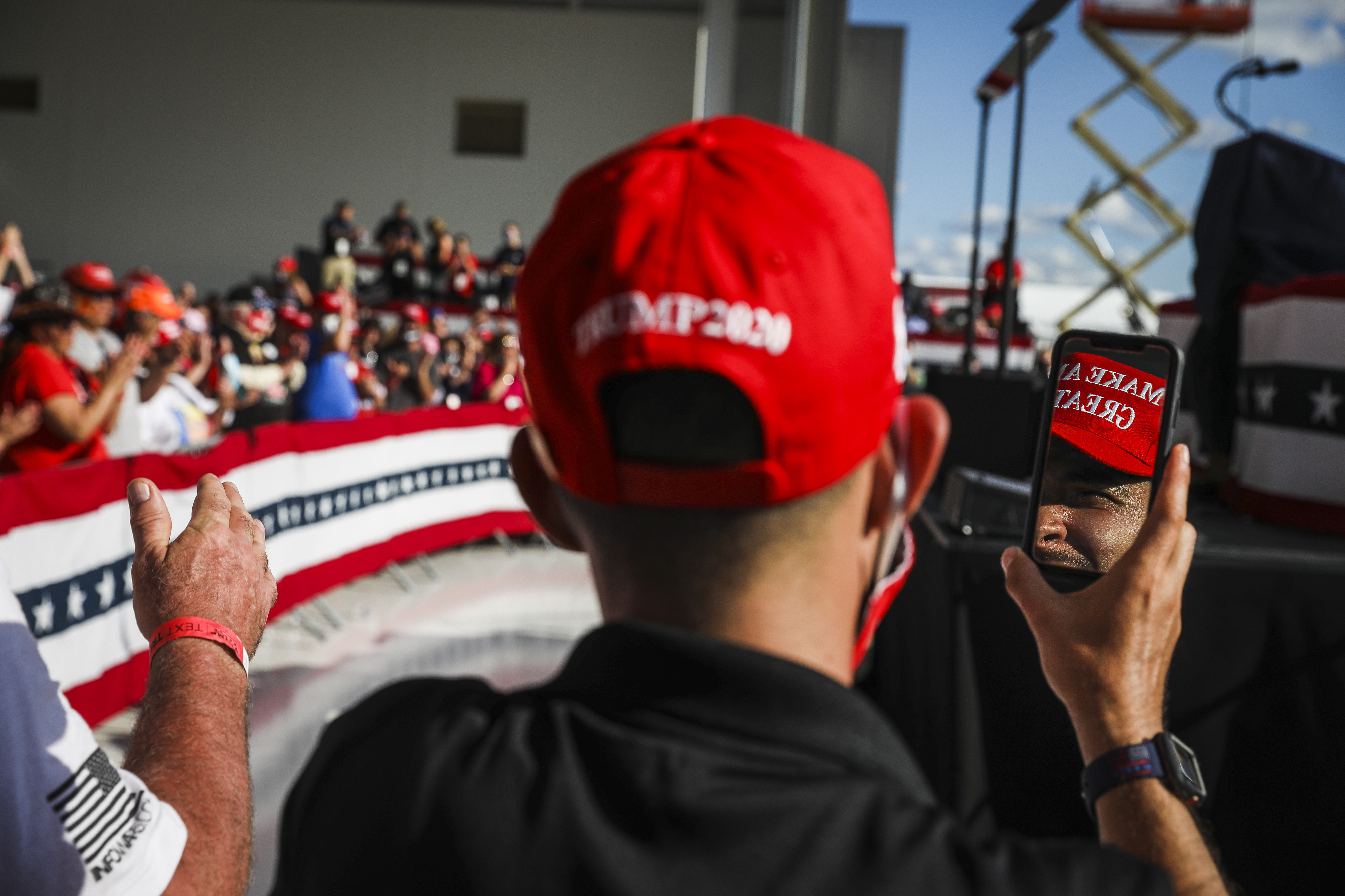 A Trump supporter was reflected in his phone while waiting for the president's arrival.