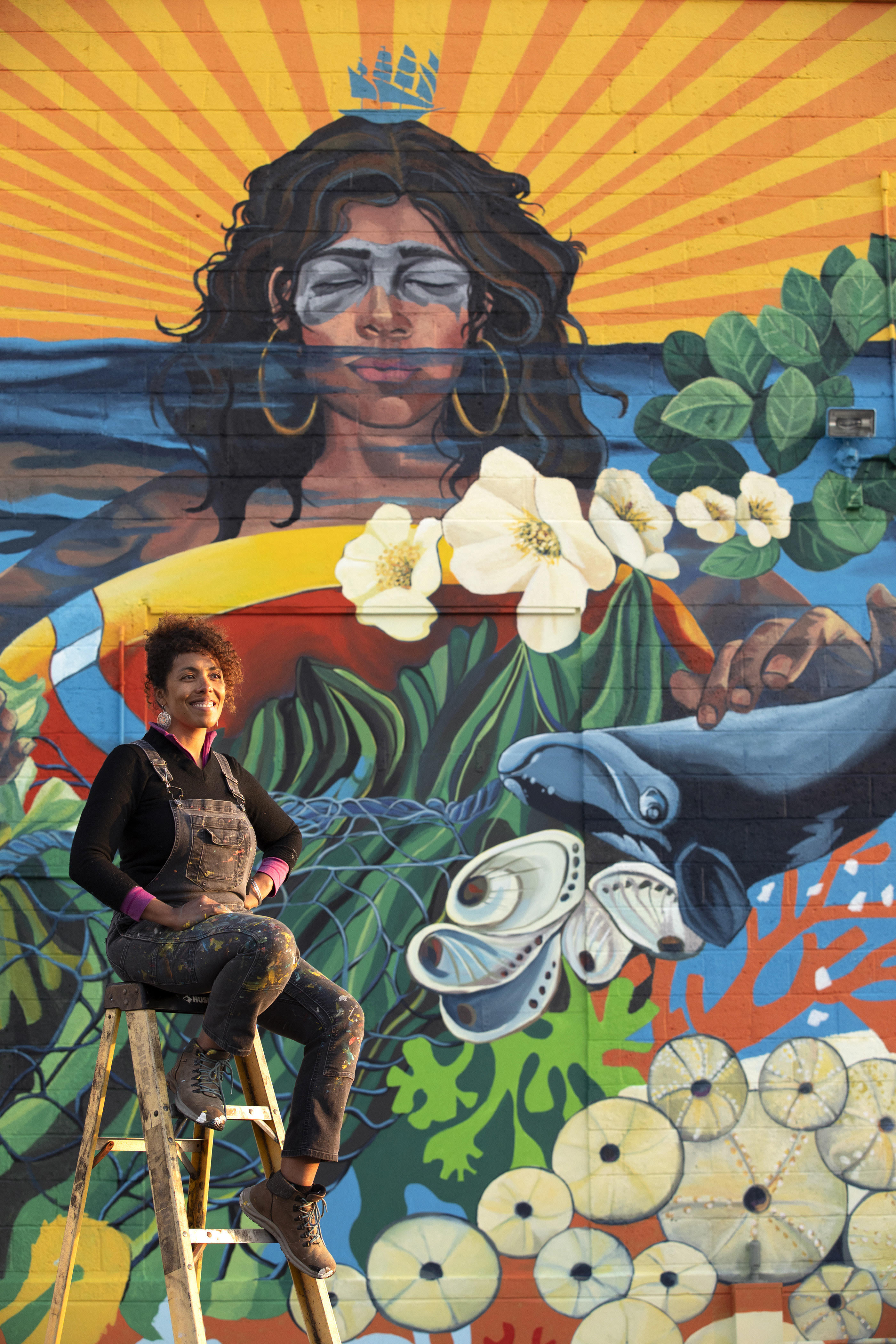 Artist Silvia López Chavez with her new work in East Boston.