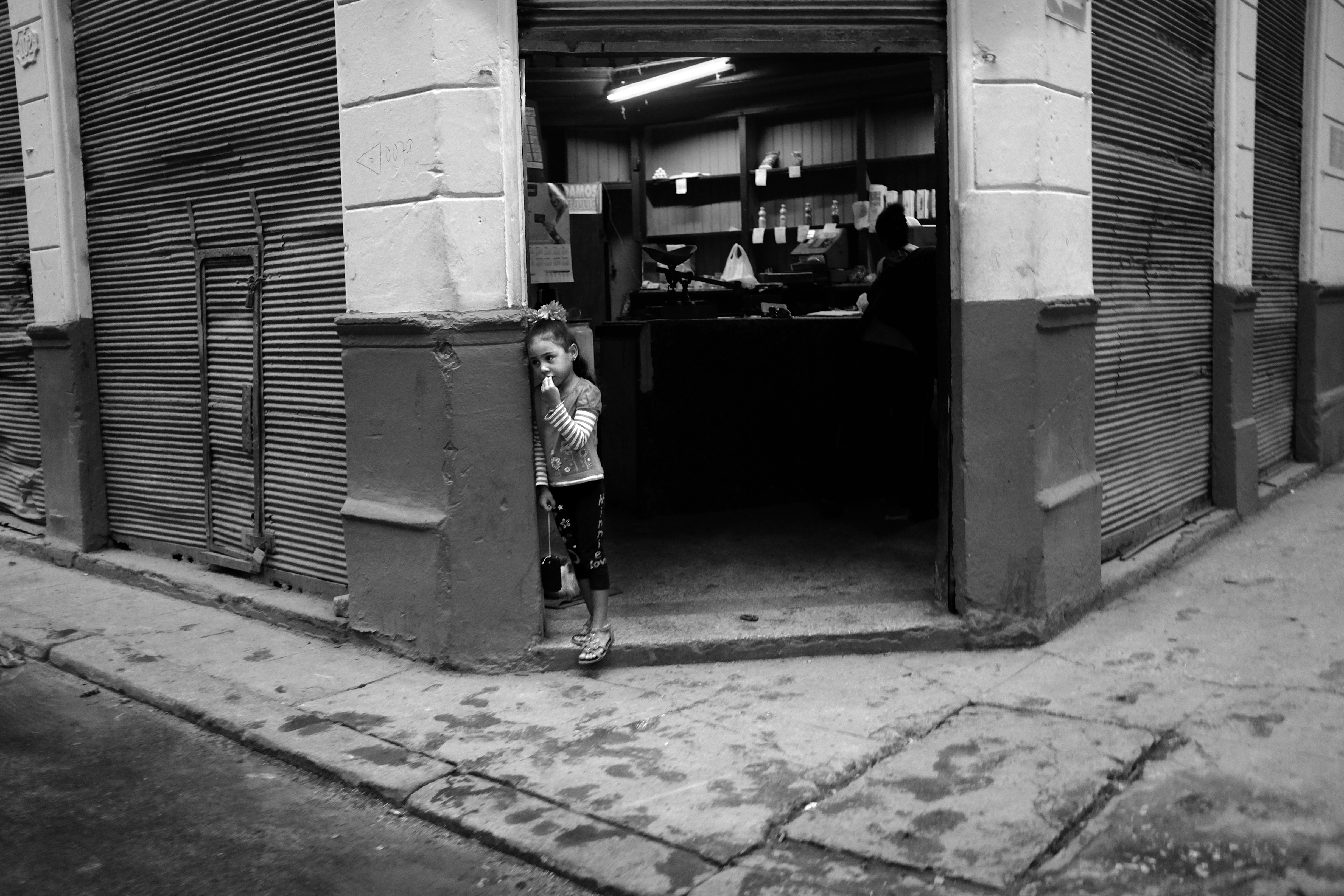 A young girl stands in a doorway in Havana.
