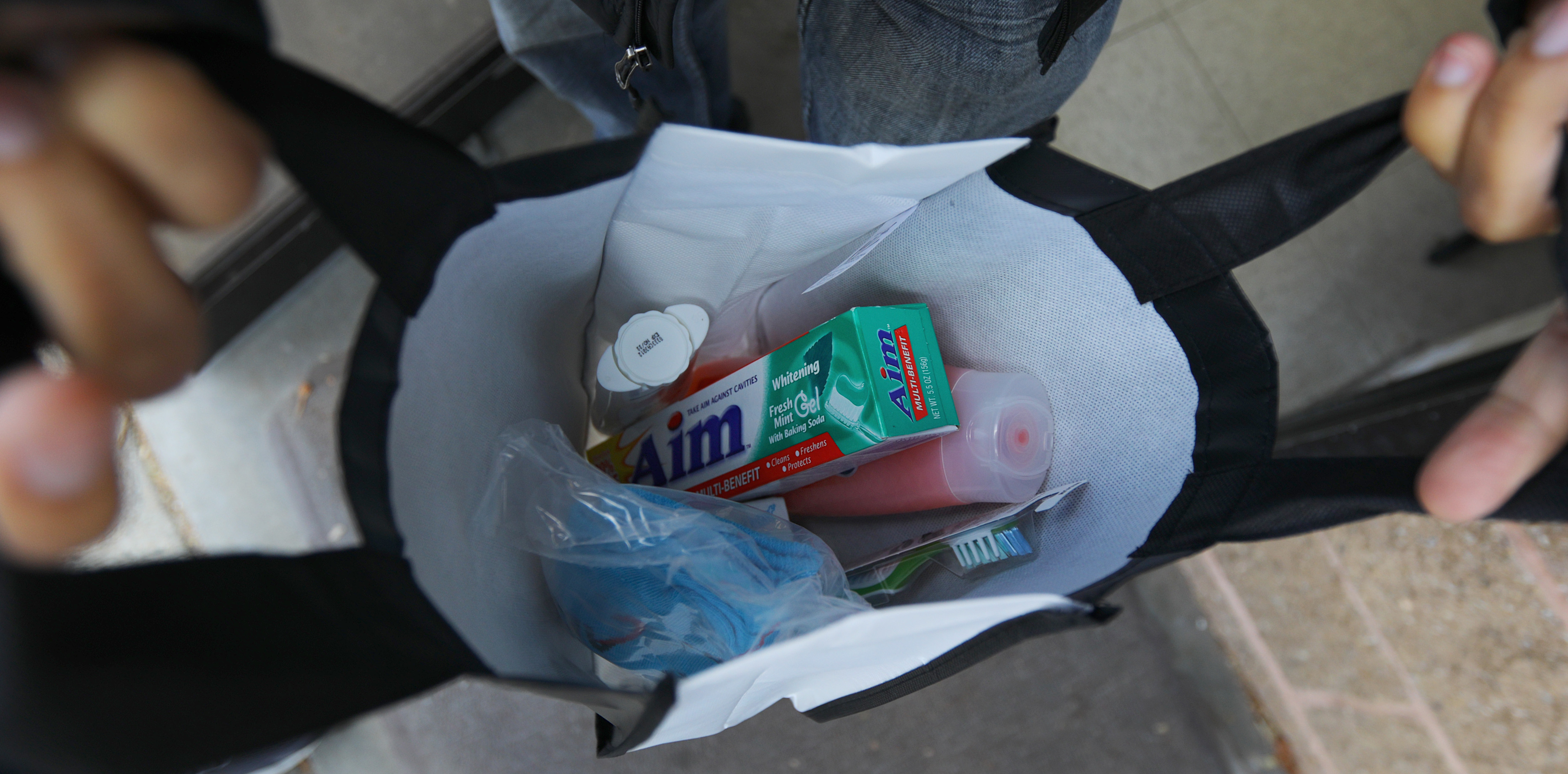 A guest is handed a bag of personal care items at Lazarus House Ministries in Lawrence.