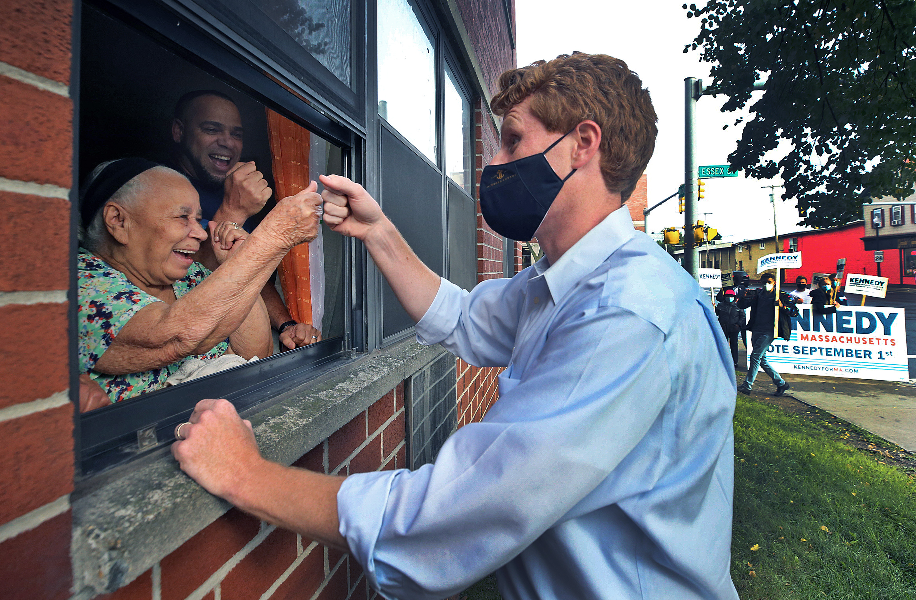Joe Kennedy III campaigned in Lawrence on Thursday. He saw a group of people waving to him from an open first-floor window, ran over, and clapped and bumped fists, speaking with them in Spanish.