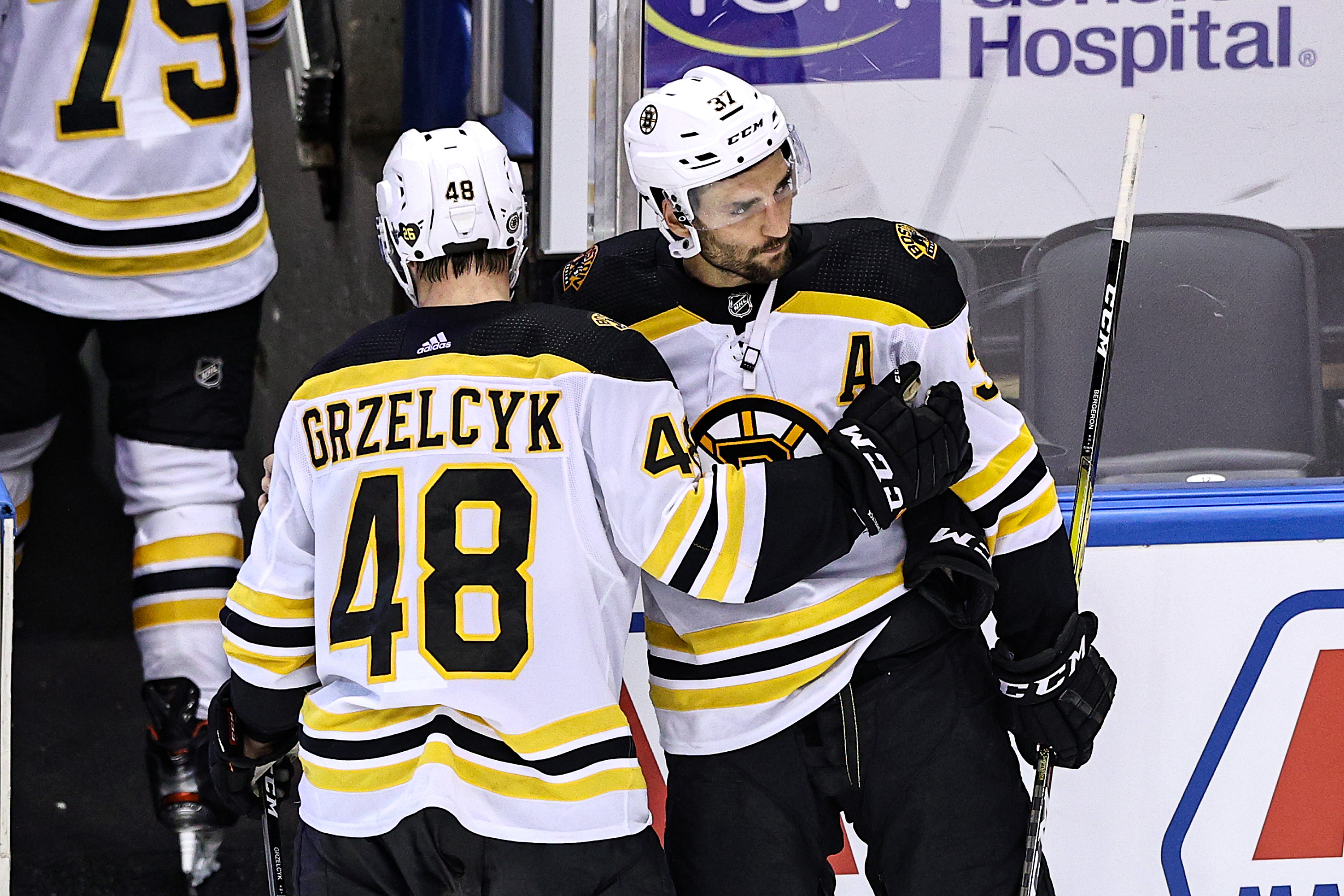 Matt Grzelcyk and Patrice Bergeron react after losing in double overtime to Tampa Bay Monday night.