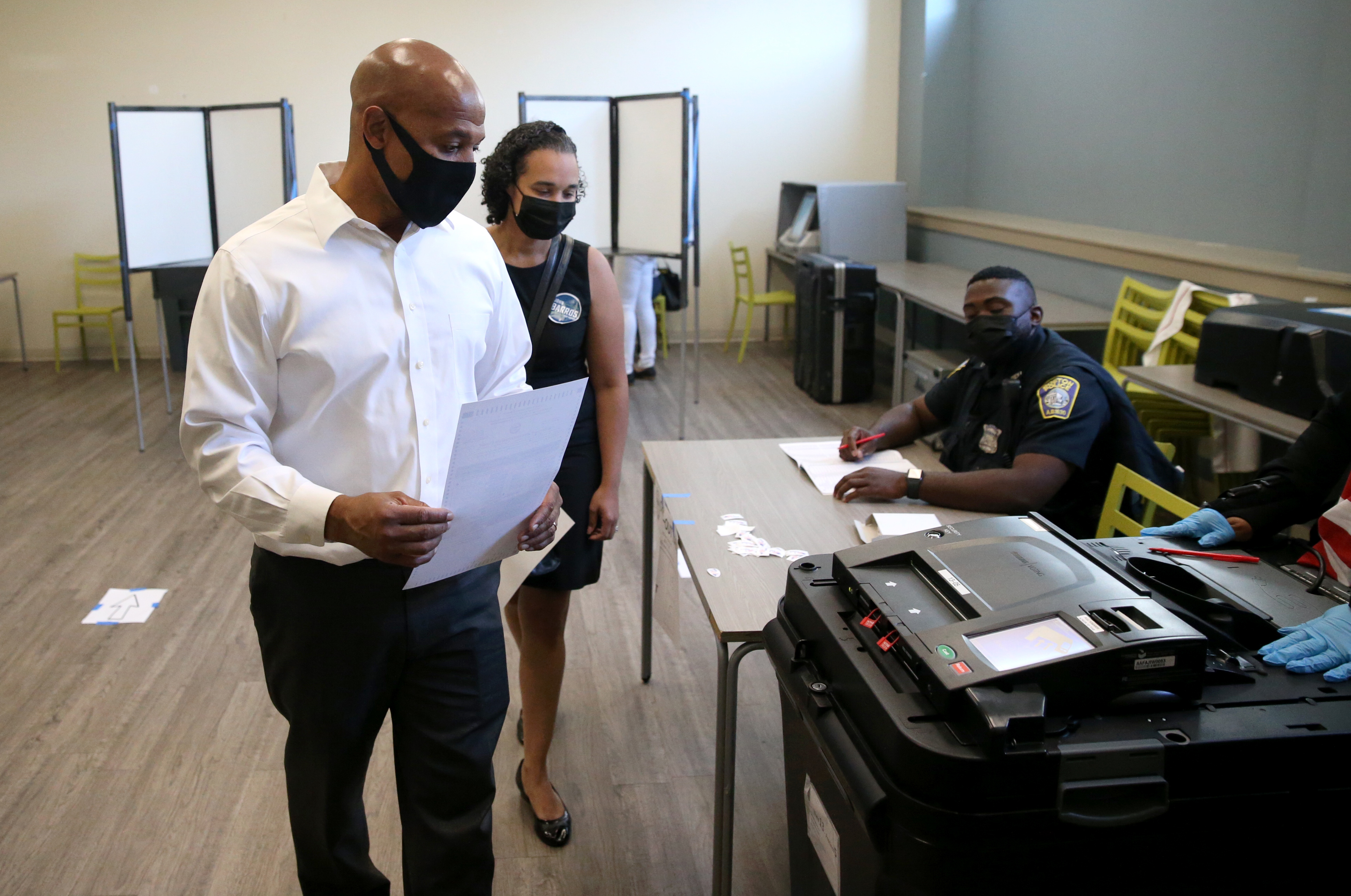 John F. Barros prepares to cast his ballot, while voting with his wife Tchintcia, at Uphams Crossing, 530 Columbia Road, in Dorchester.