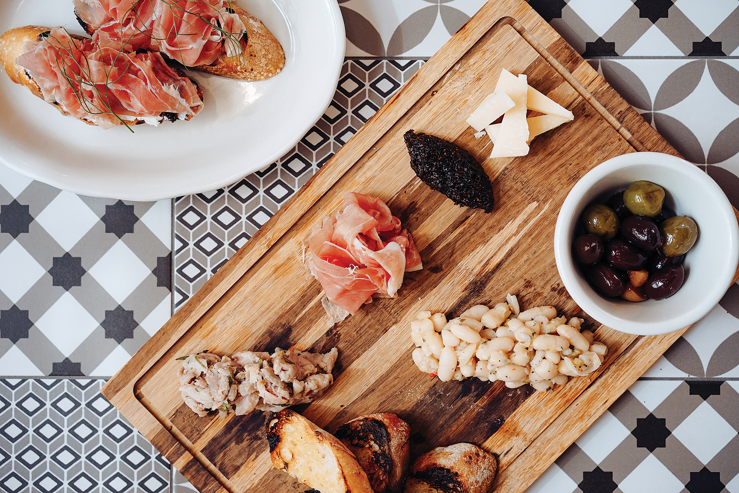 Credit Newport Restaurant Group.
Picture of the antipasti plate at Bar ’Cino, which includes cured meat, parmesan, marinated white beans, evoo tomatoes, caponata, olives, grilled bread, and fig jam.