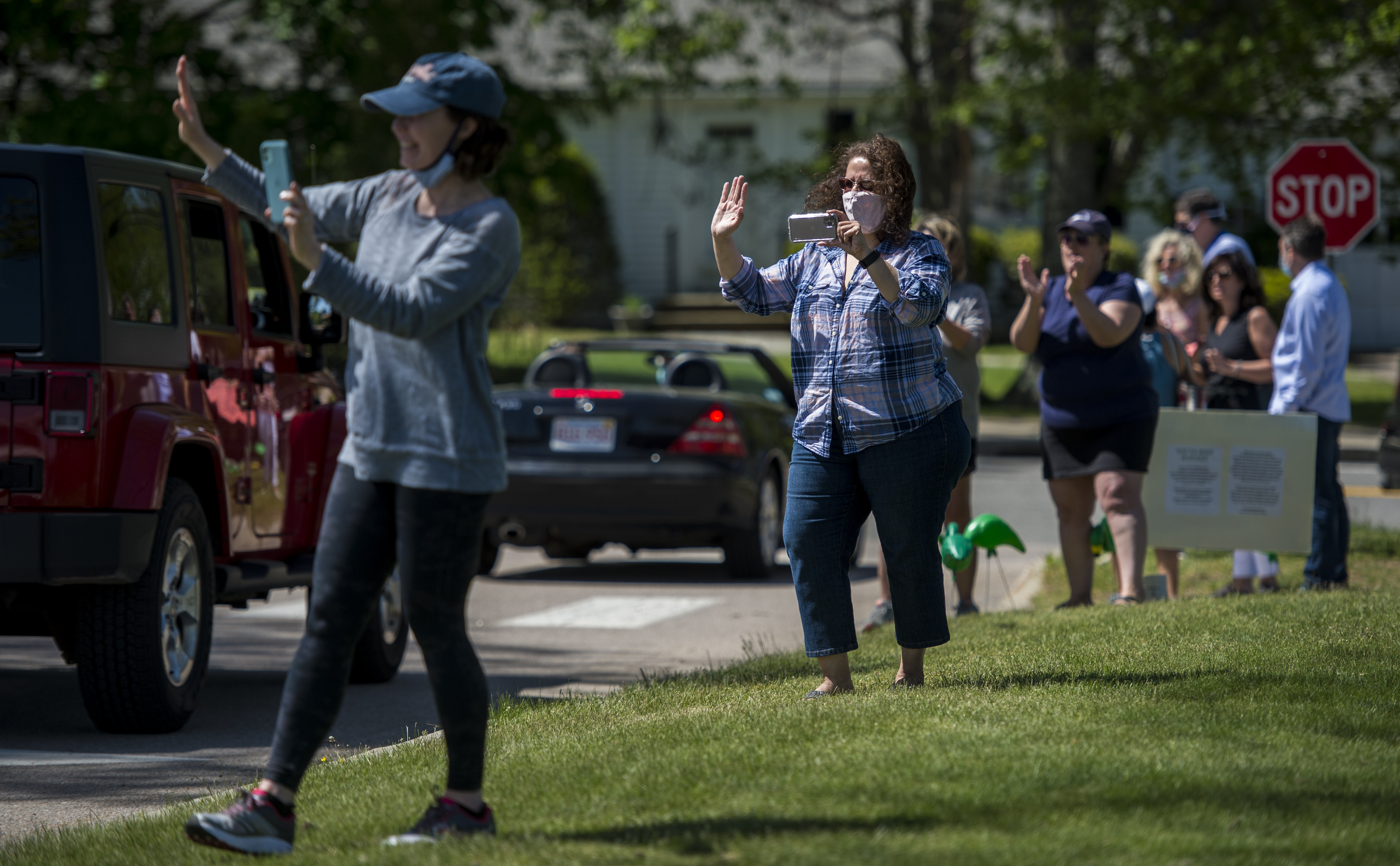 Parents and faculty cheer on graduating seniors from the Westwood High School Class of 2020 as they have a "drive-out" in place of their usual tradition of having a walkout to honor the graduating seniors.