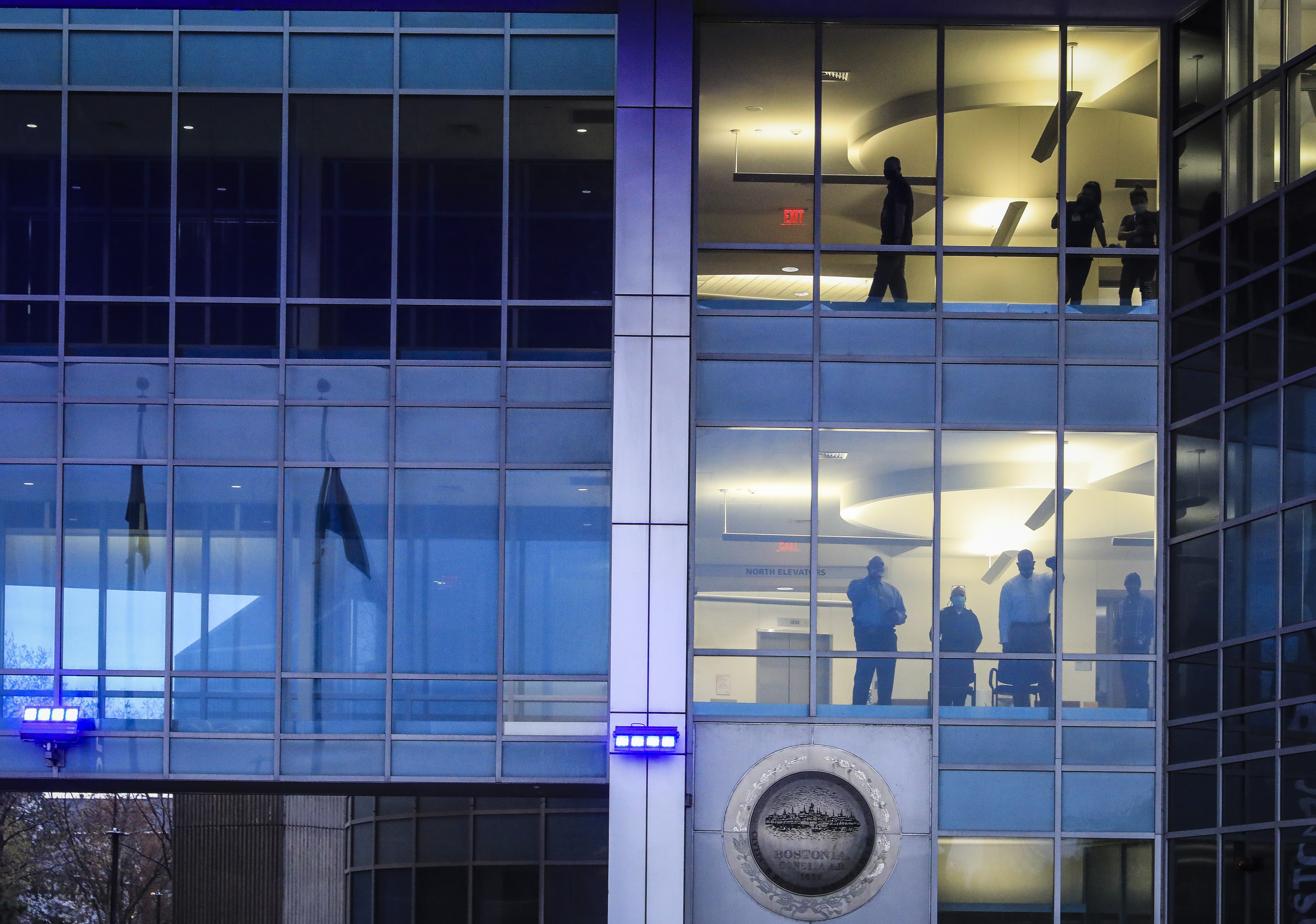 People watched from inside BPD headquarters on April 21 as protesters gathered out front to celebrate the conviction of former Minneapolis police officer Derek Chauvin and to demand an end to police brutality.
