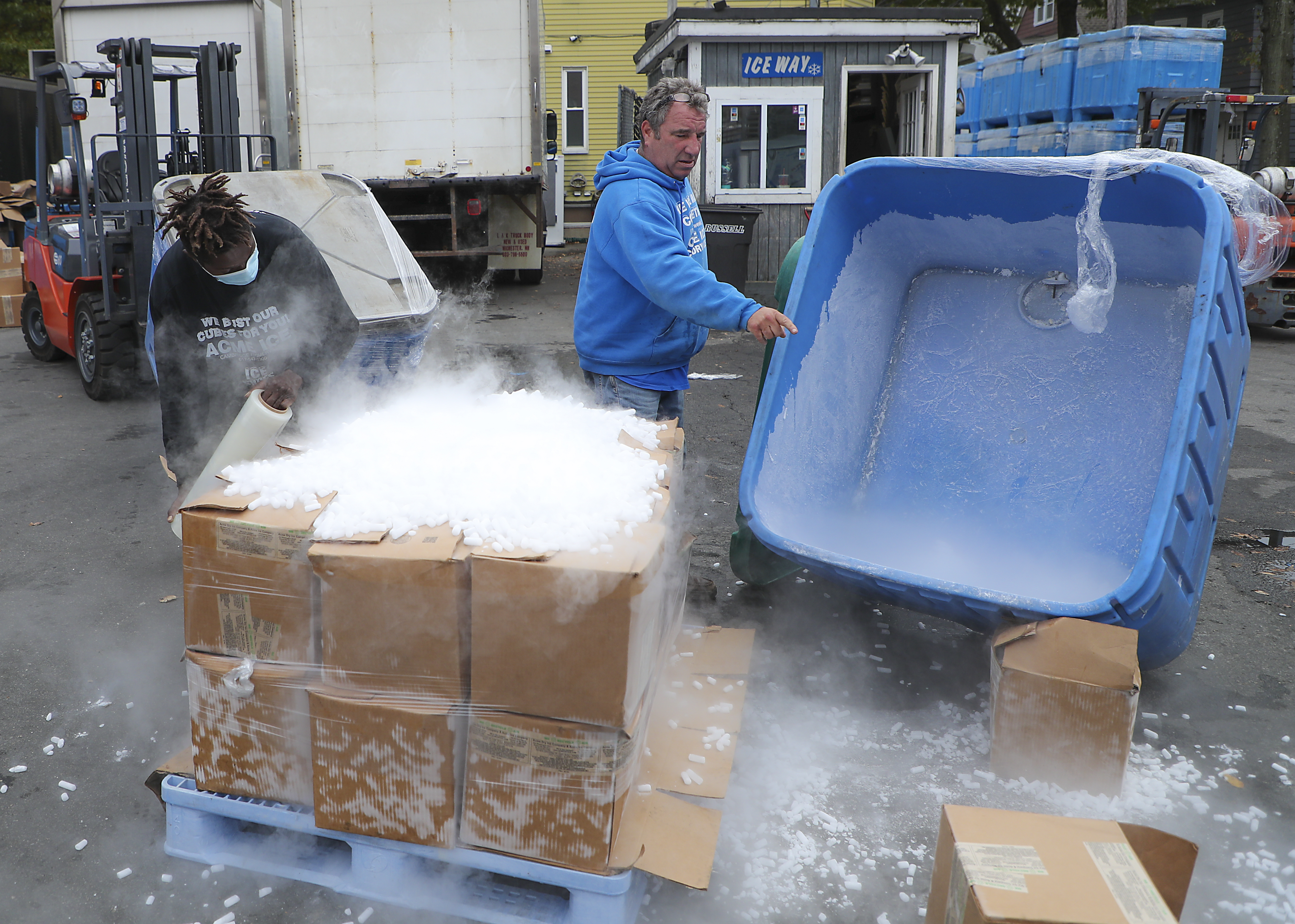 Charlie Ehizuelen (left) helped Marc Savenor prepare a pallet of dry ice.