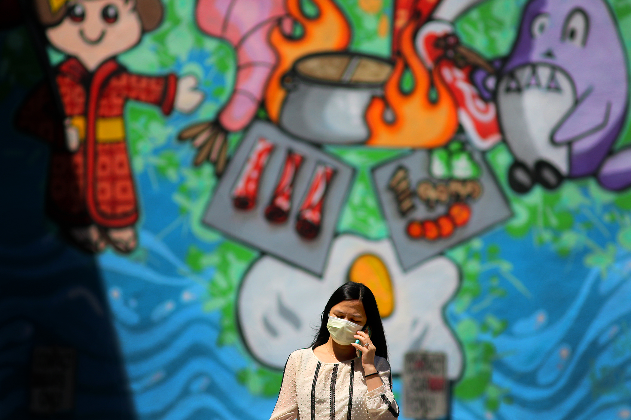A pedestrian passed a mural advertising Kaze Shabu Shabu restaurant on Harrison Avenue in Chinatown on May 21.