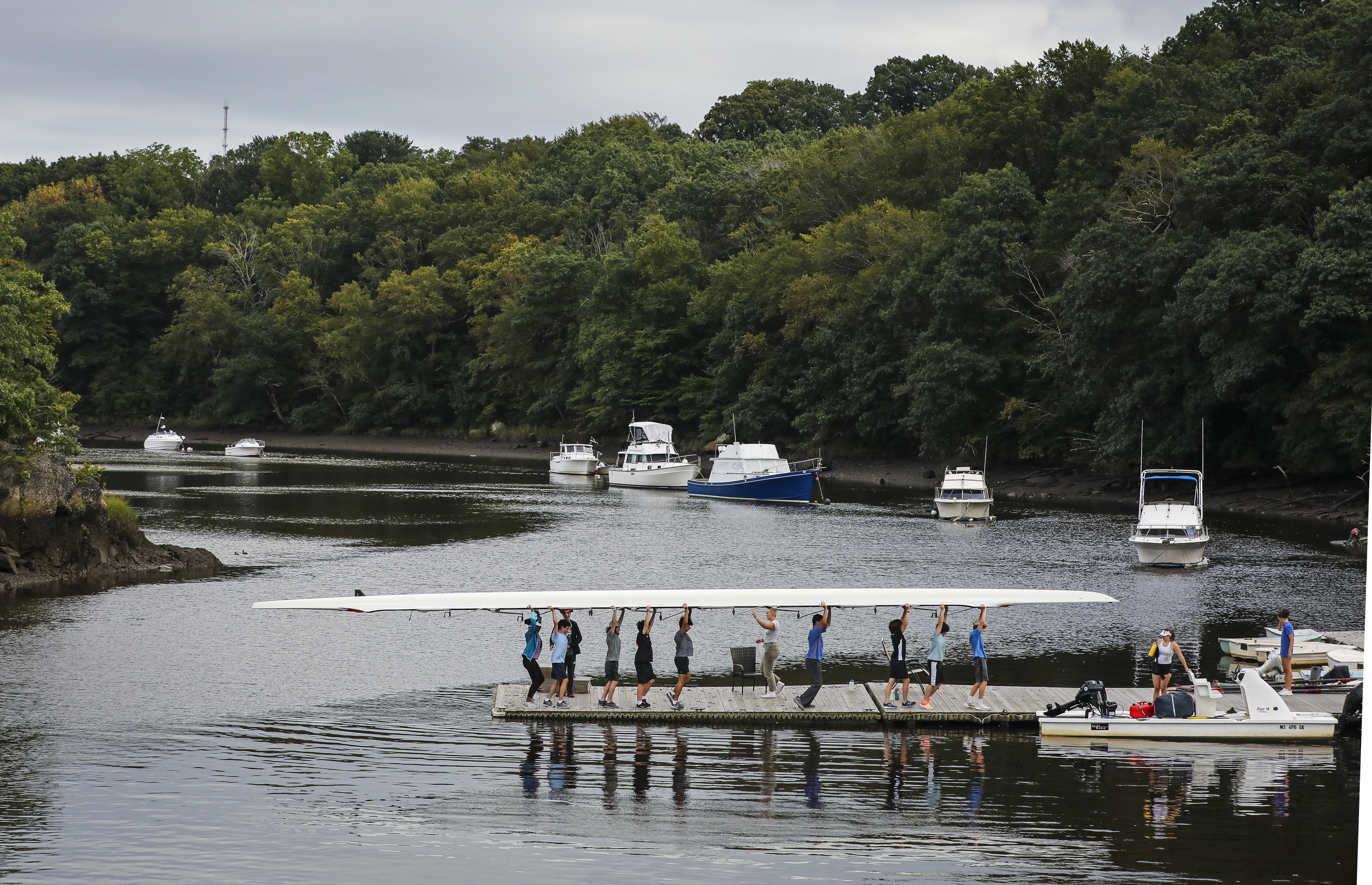 Milton high school students carried in their boat after rowing along the Neponset River near Baker Dam in Lower Mills.