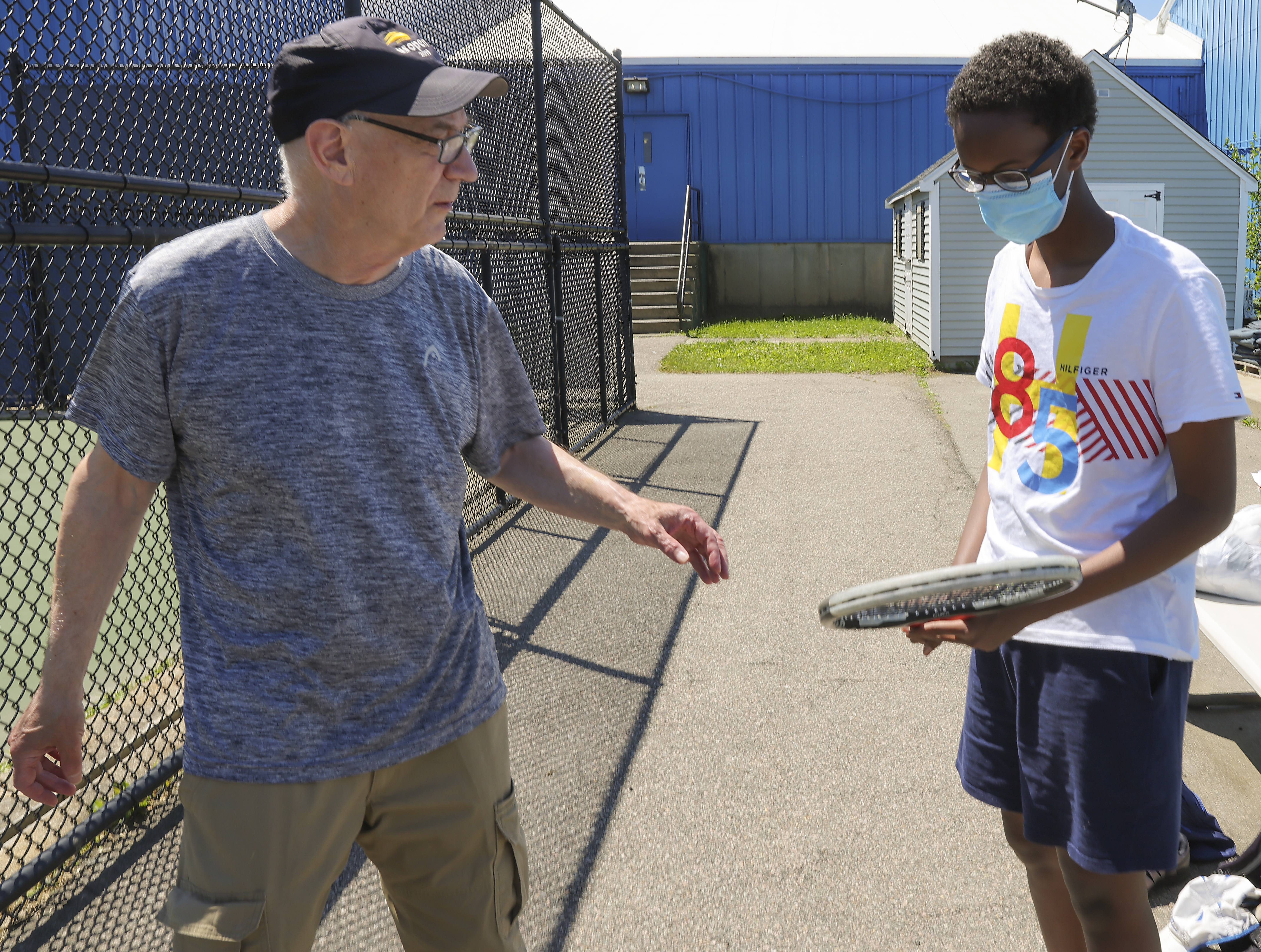 Sportsmen's tournament director Andy Crane is happy to lend a racket to 16-year-old Liban Mohamed.