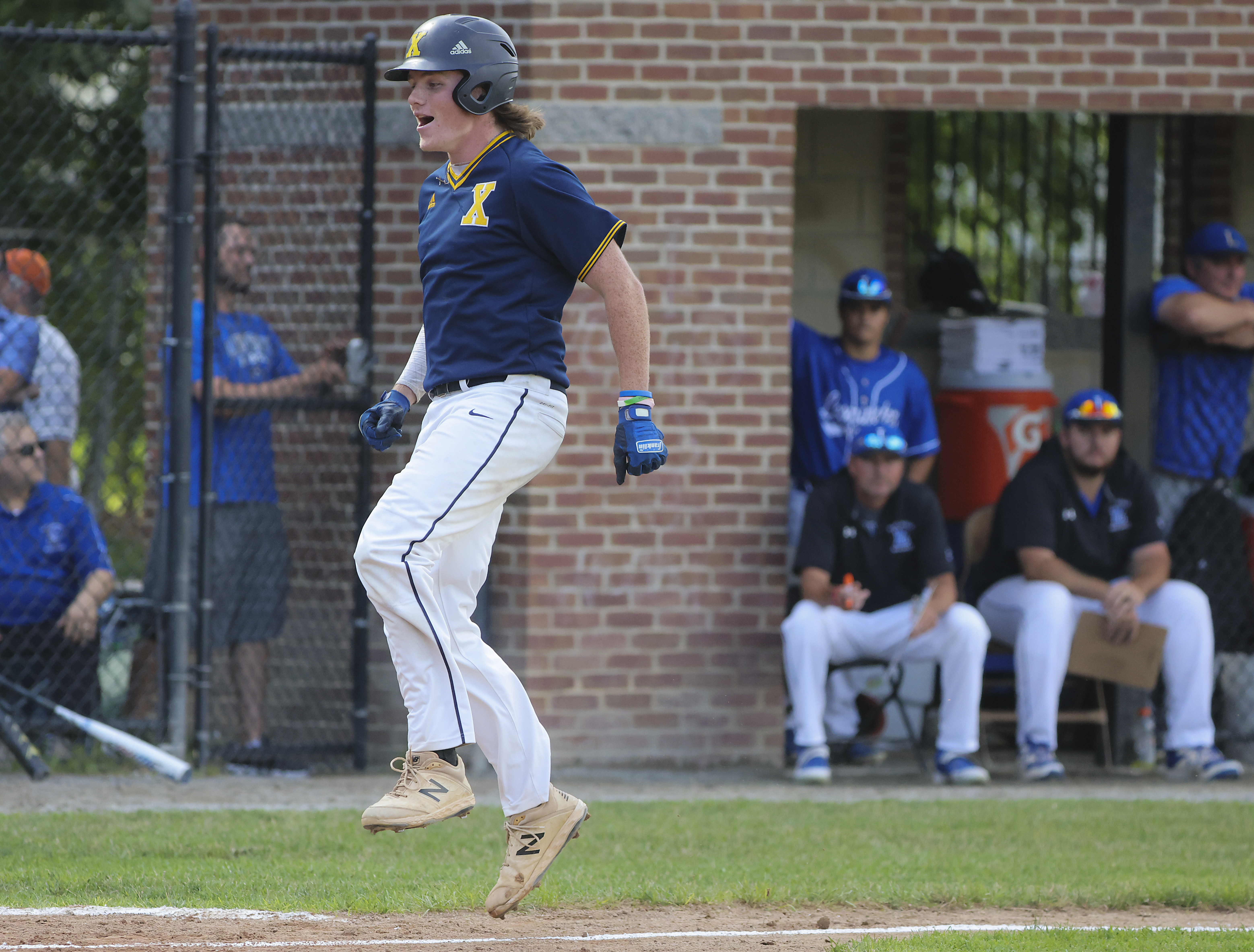 Xaverian's John Connolly leaps towards home plate after hitting a solo home run against Leominster in the fourth inning.