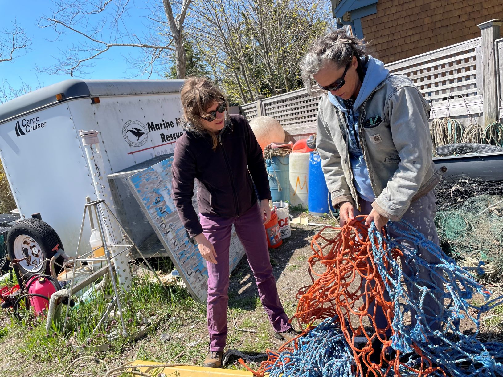 Laura Ludwig, in gray, and artist Annie Lewandowski inspect rope.
