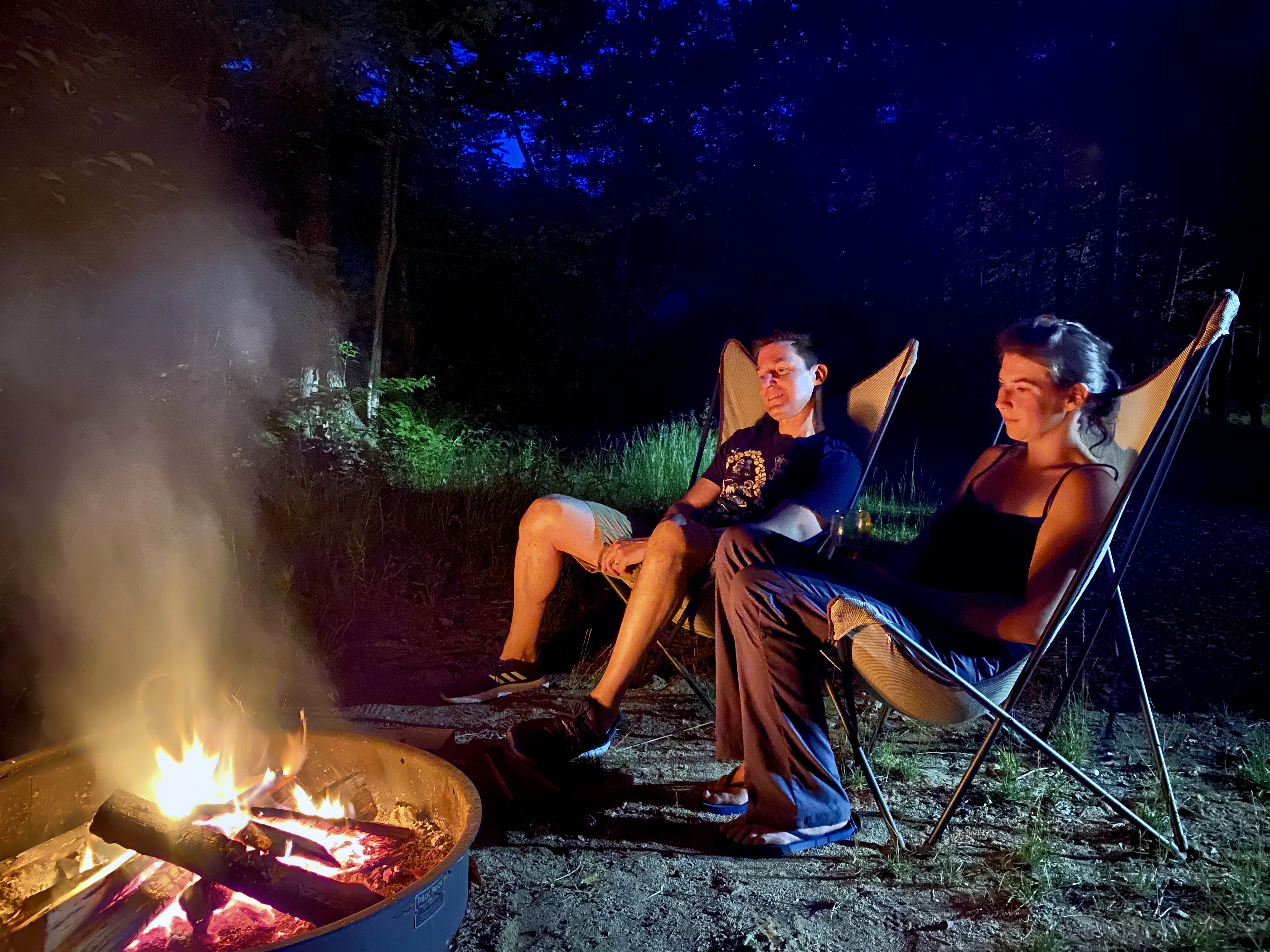 Christopher Muther and his niece Jennifer Hache sit by the fire at Huttopia White Mountains in Albany, N.H.