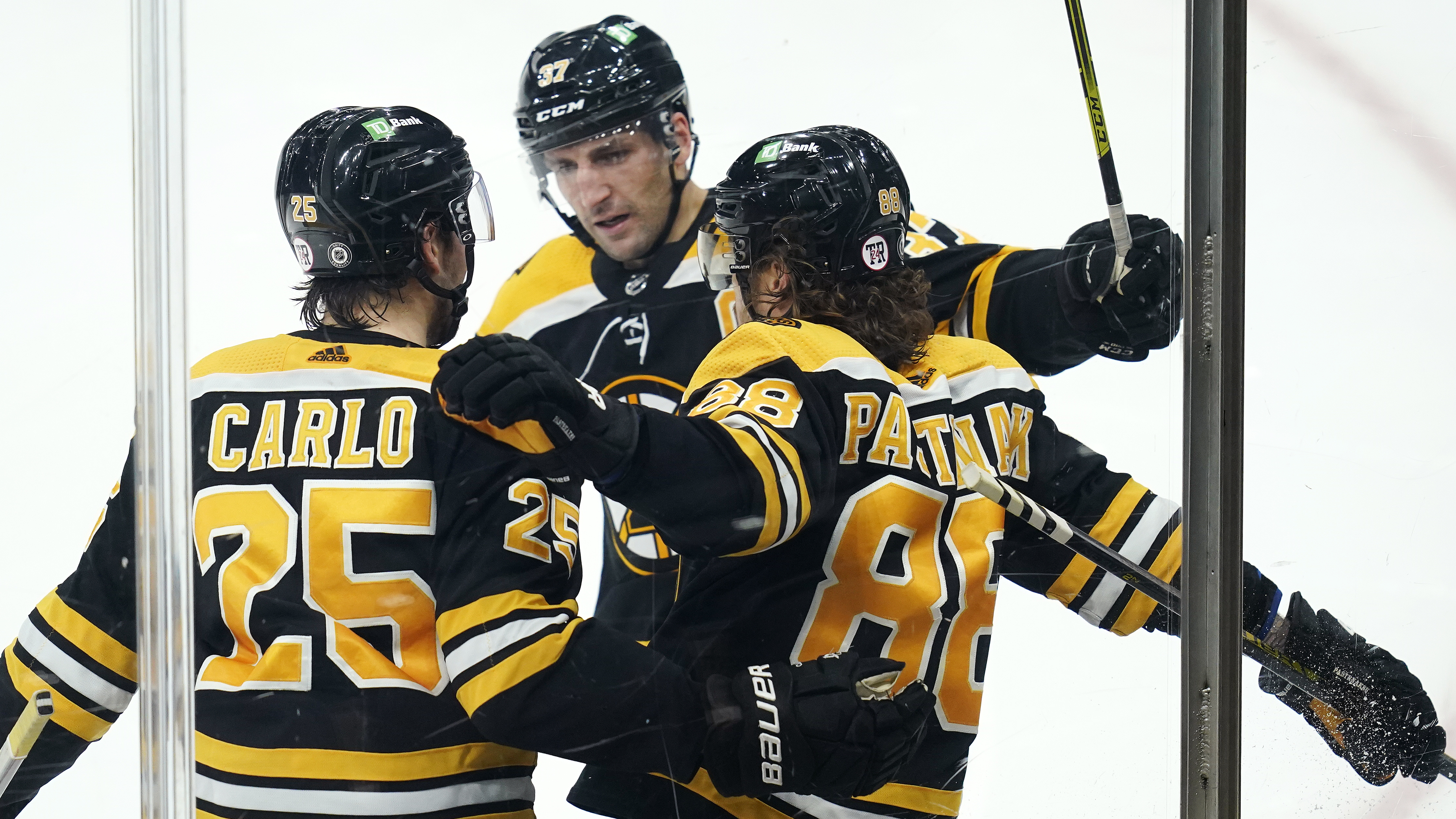 David Pastrnak (88) is congratulated by Brandon Carlo (25) and Patrice Bergeron after his third-period-goal Wednesday night.
