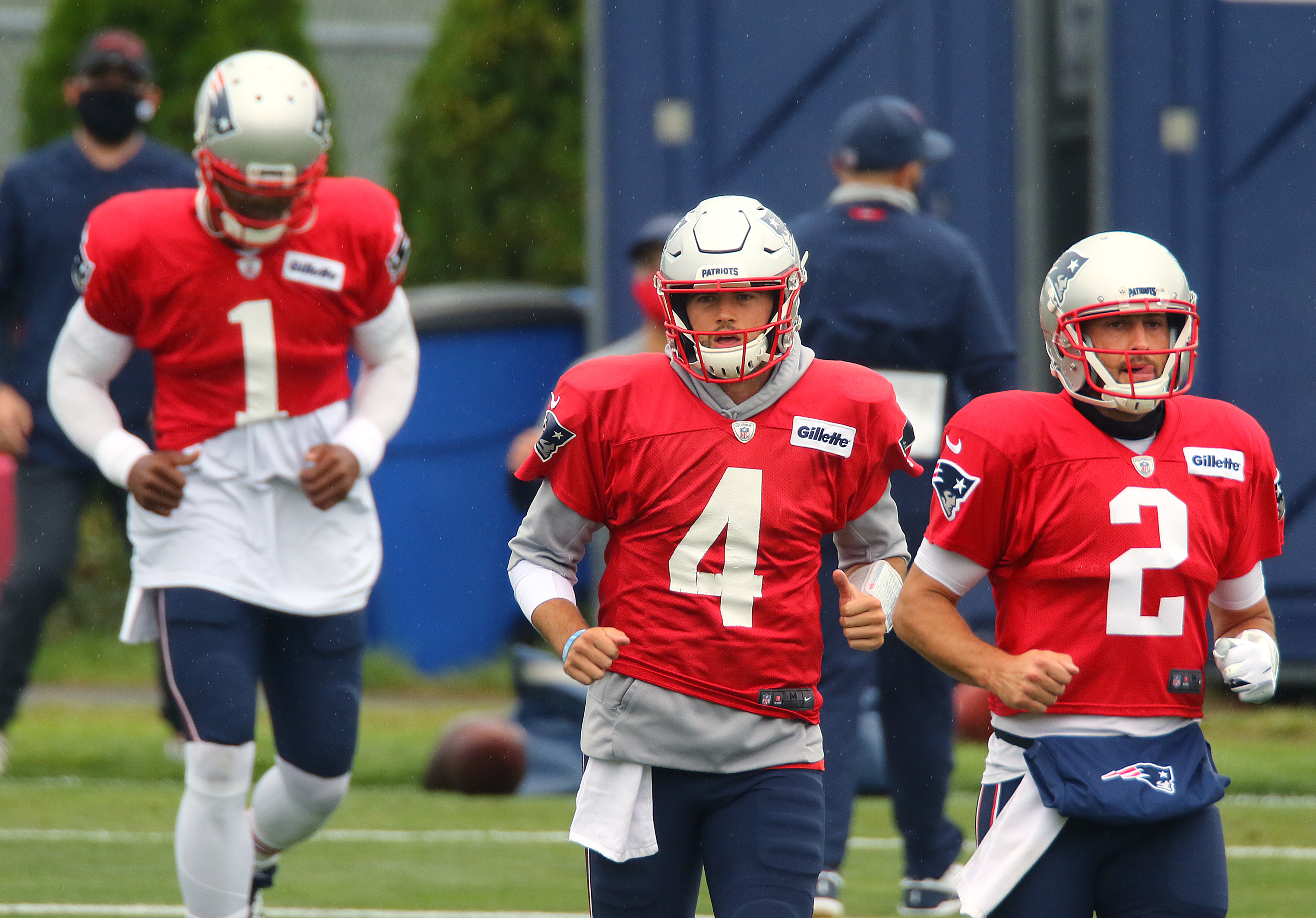 Quarterbacks Cam Newton, Jarrett Stidman and Brian Hoyer run at the start of a passing drill Thursday.