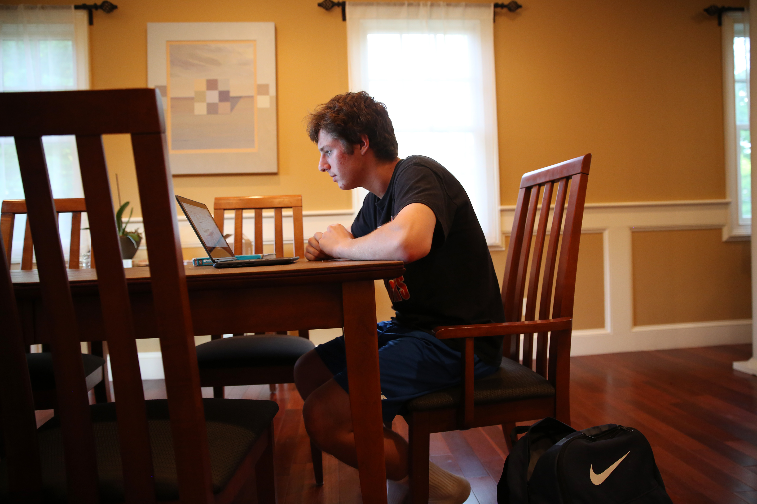 Newton South sophomore Daniel Glickman did homework at his family’s dining room table after lacrosse practice.