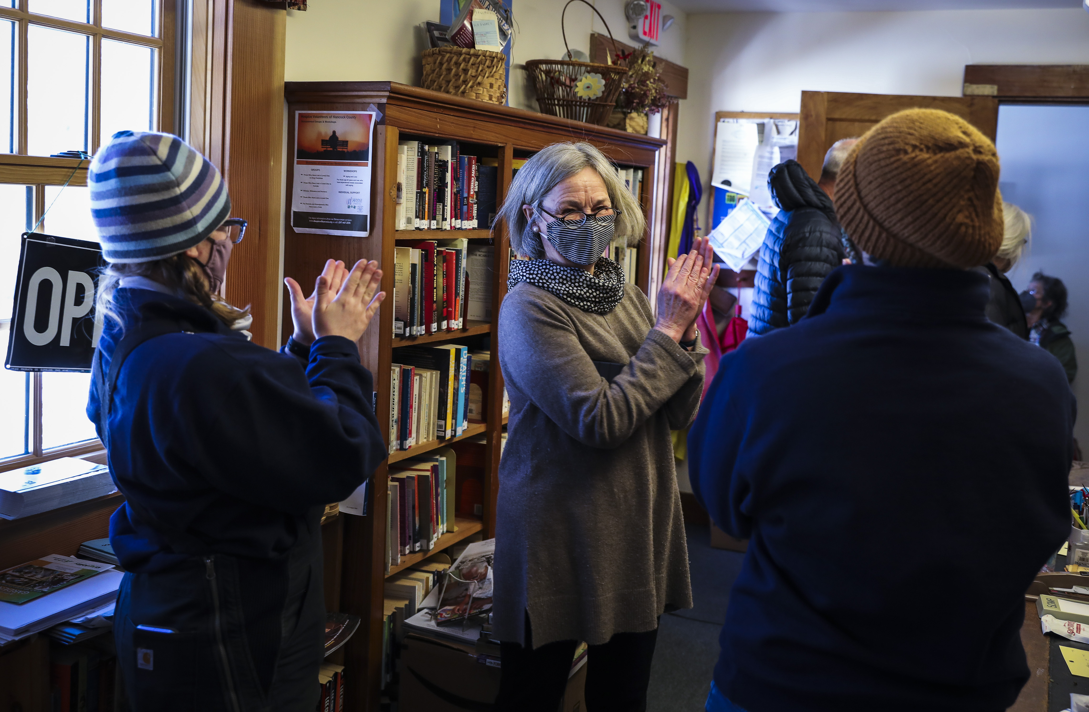 Katelyn Damon, (left) chief of Cranberry Isles Rescue Service; Barb Fernald, (center) an Islesford resident; and Mary Schuch, assistant chief of Cranberry Isles Rescue Service, applauded Seacoast Mission staff after they vaccinated islanders at the local library in Islesford.