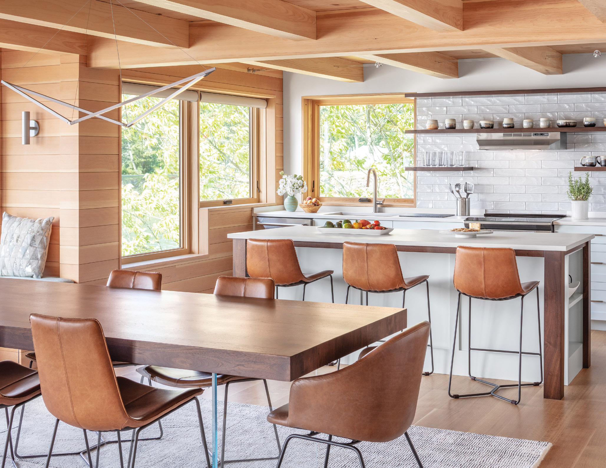 Walnut and leather elements in the kitchen and dining area add contrast to the lighter tones and warmth to the space.