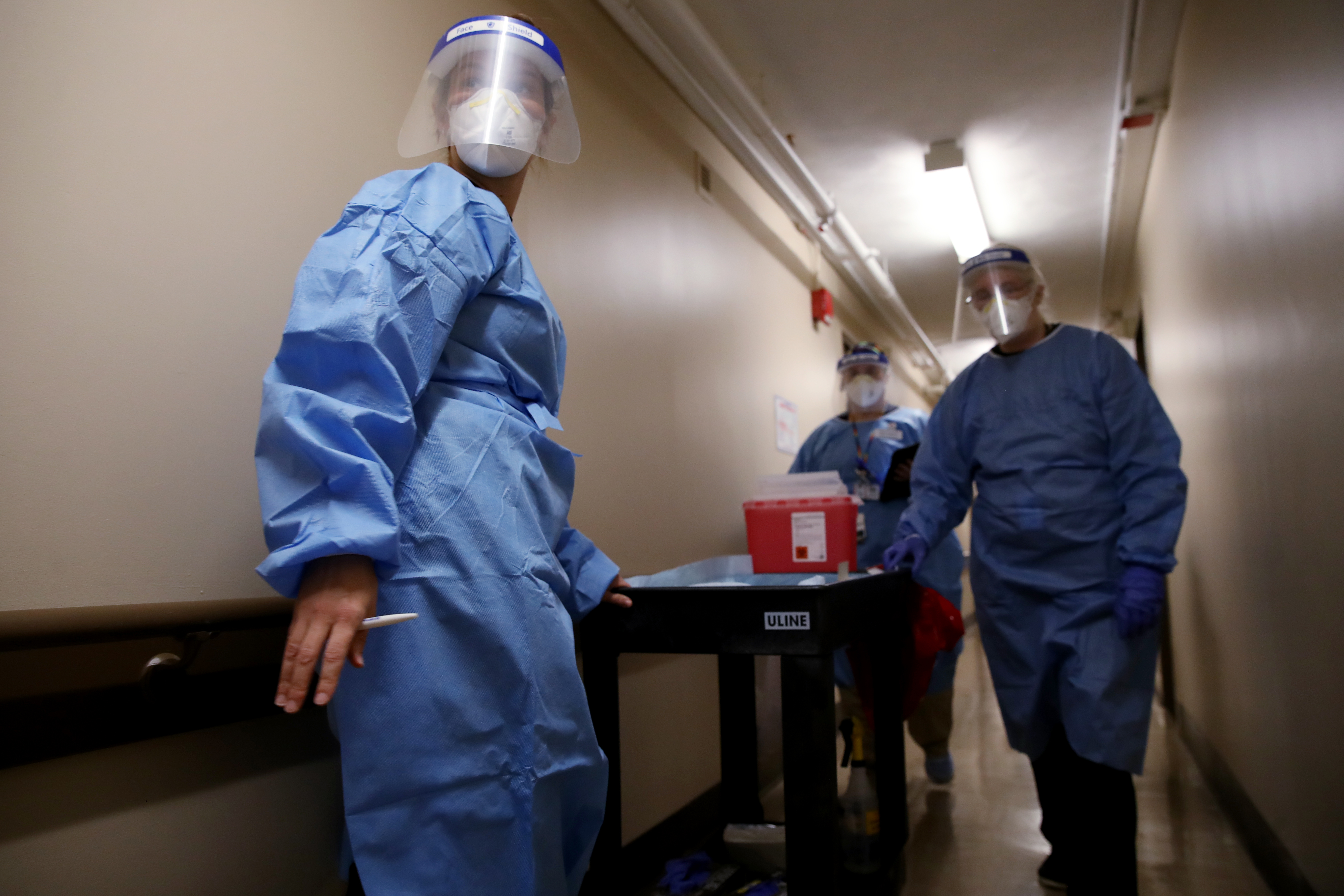 Dr. Katie Fleming leads a team through a hallway while administering the Moderna COVID-19 Vaccine at Forand Manor in Central Falls, Rhode Island.