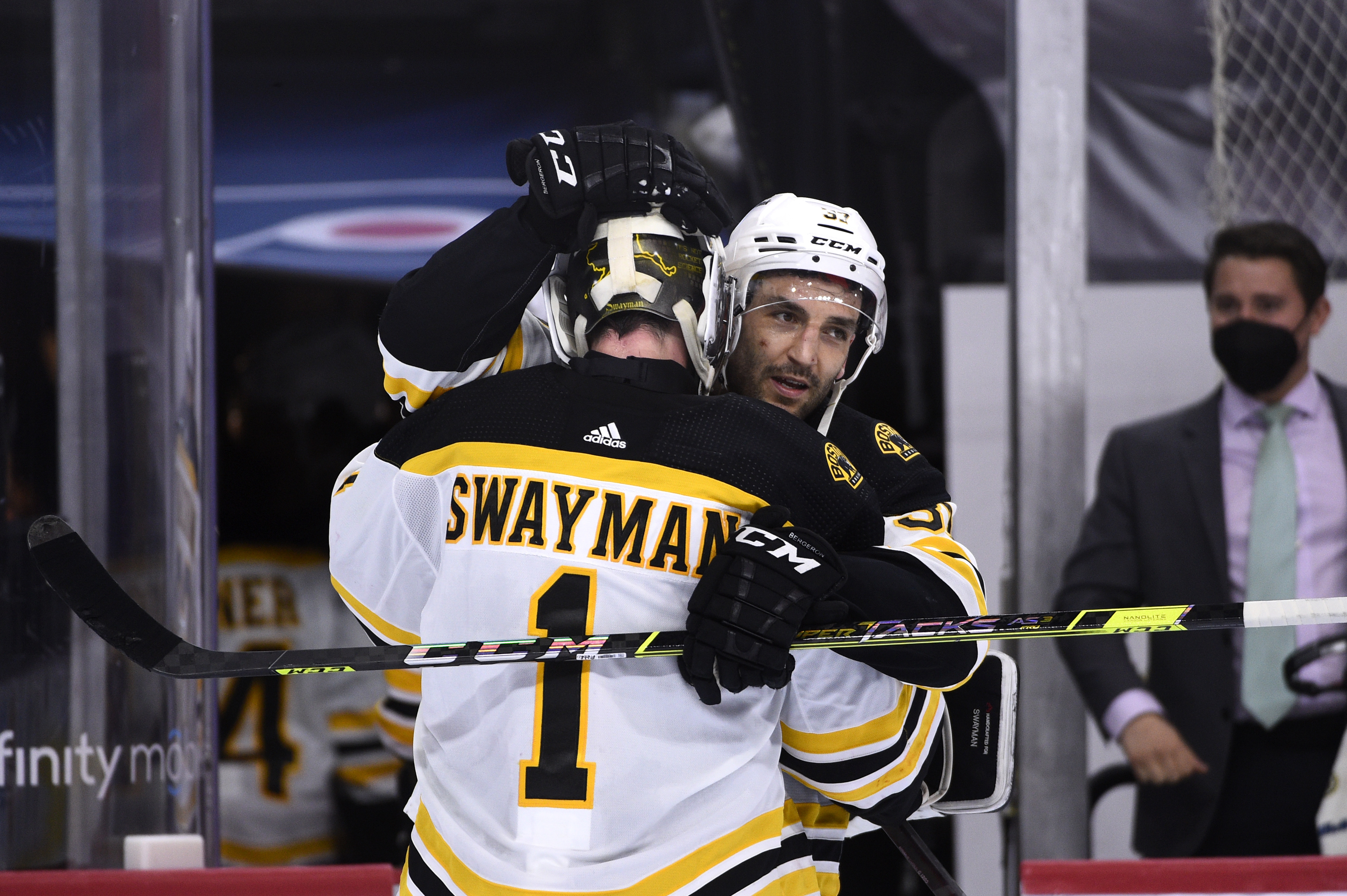 Patrice Bergeron celebrates with Jeremy Swayman after Boston's win over Philadelphia Tuesday night.