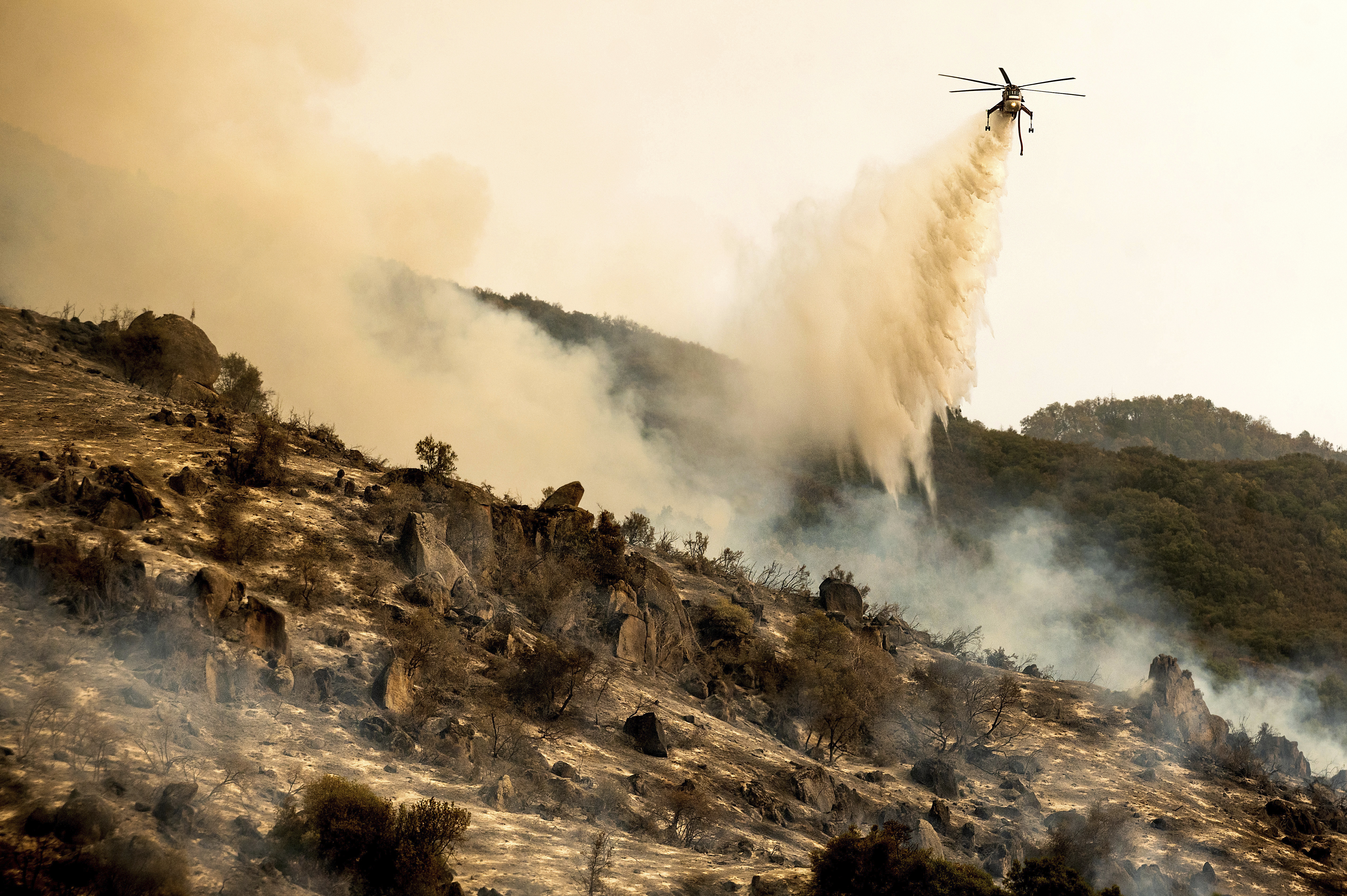 A helicopter dropped water on the KNP Complex Fire burning along Generals Highway in Sequoia National Park, Calif., on Wednesday.