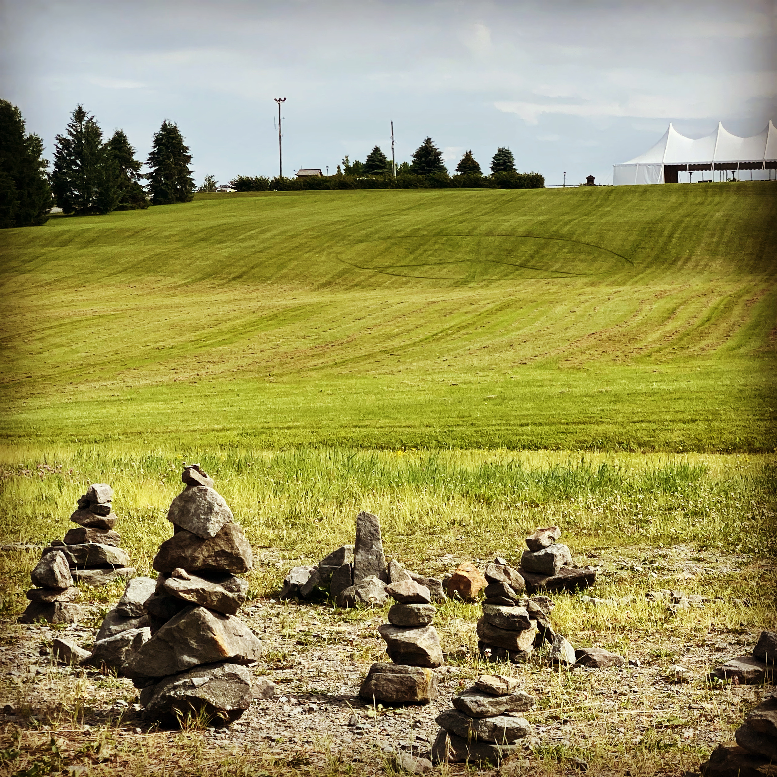 Rock cairns at the Woodstock stage site on the old Yasgur farm in Bethel, New York.  Note the peace sign mowed in the grass.