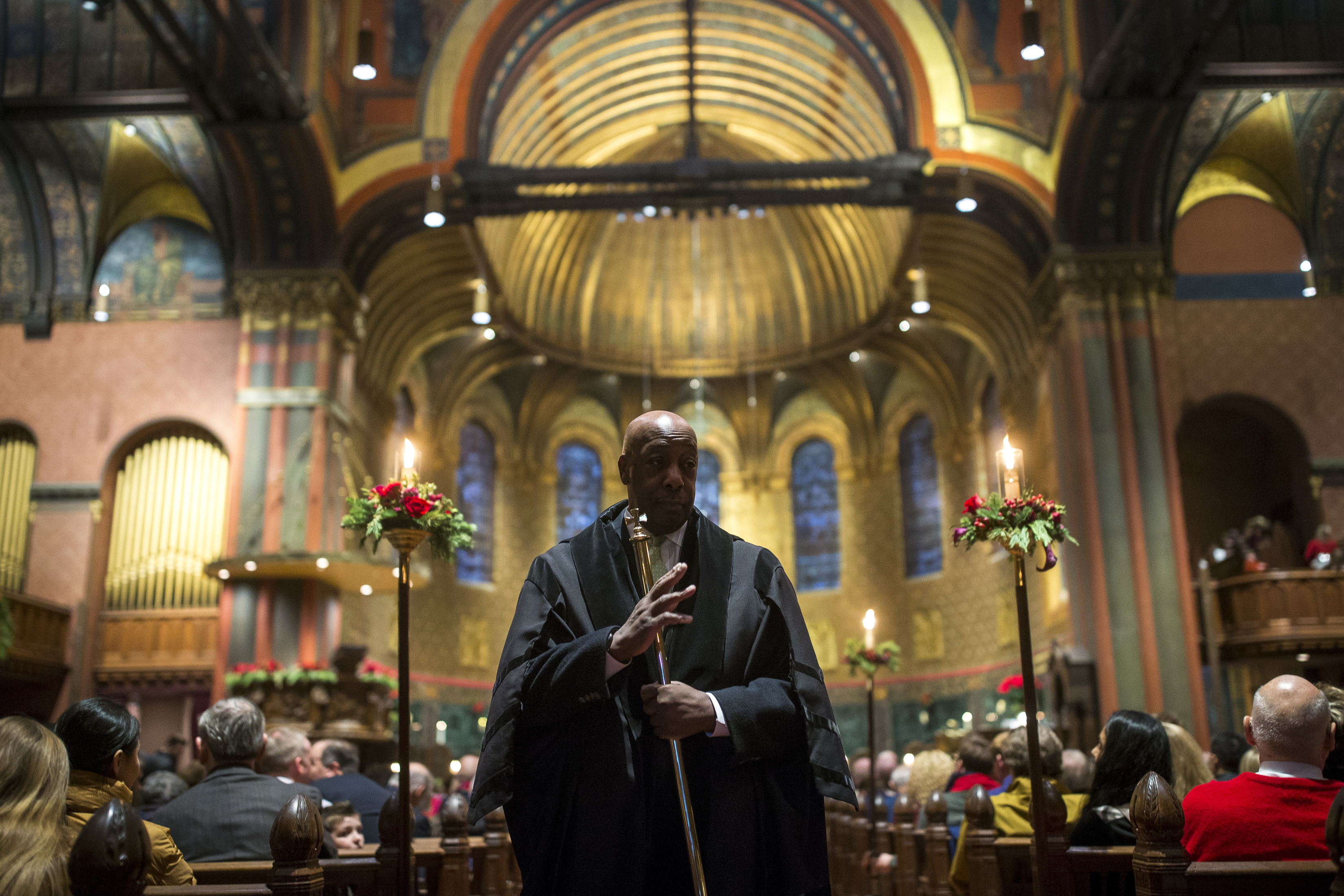 Verger Robert E. Yearwood waved to an attendee of the Christmas Eve service at Trinity Churchin Boston on Dec. 24.