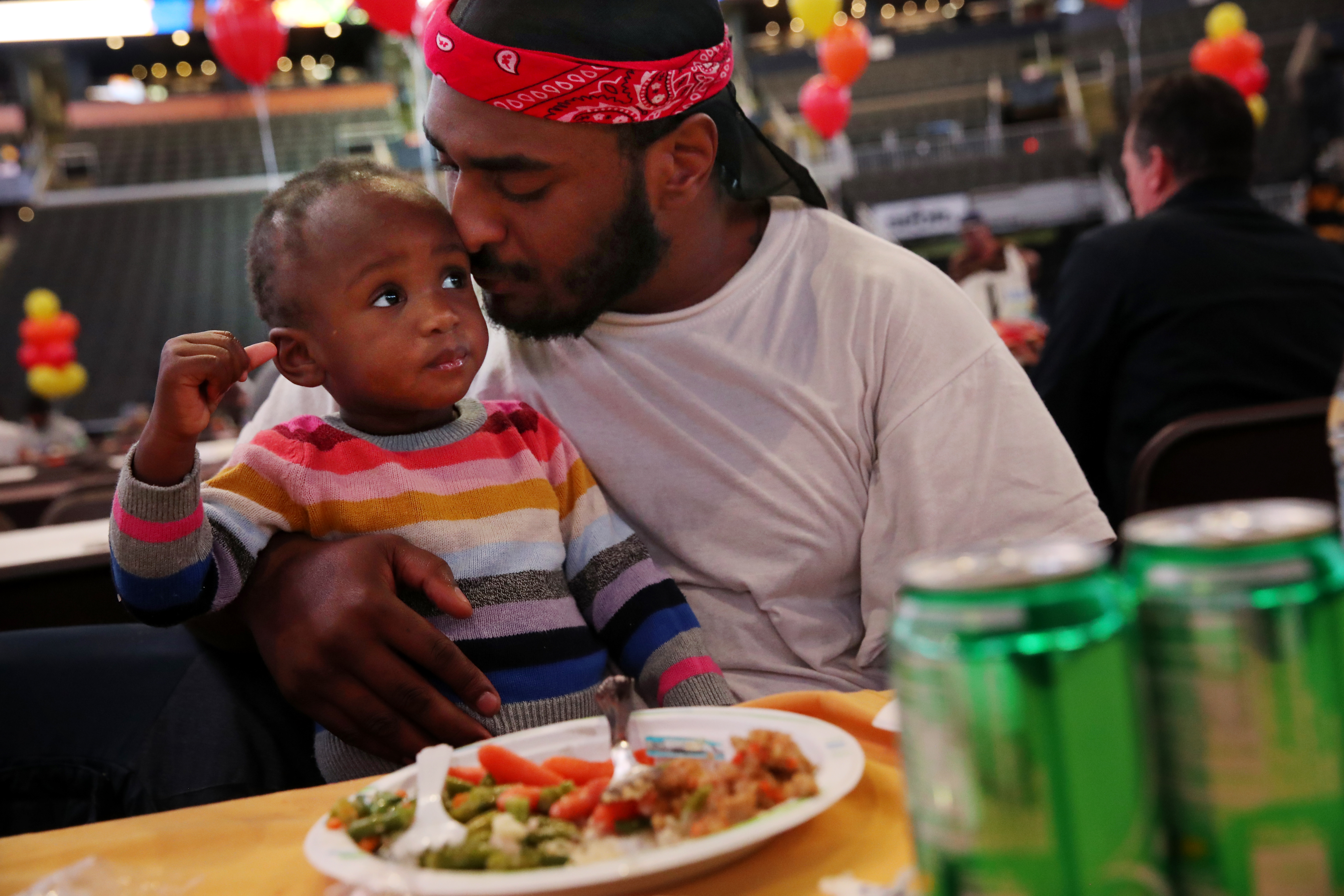 Jaquail Owens and his daughter Tailynn Lewis, 14 months, during Table of Friends, the Garden Neighborhood Charities annual Thanksgiving Dinner at TD Garden.