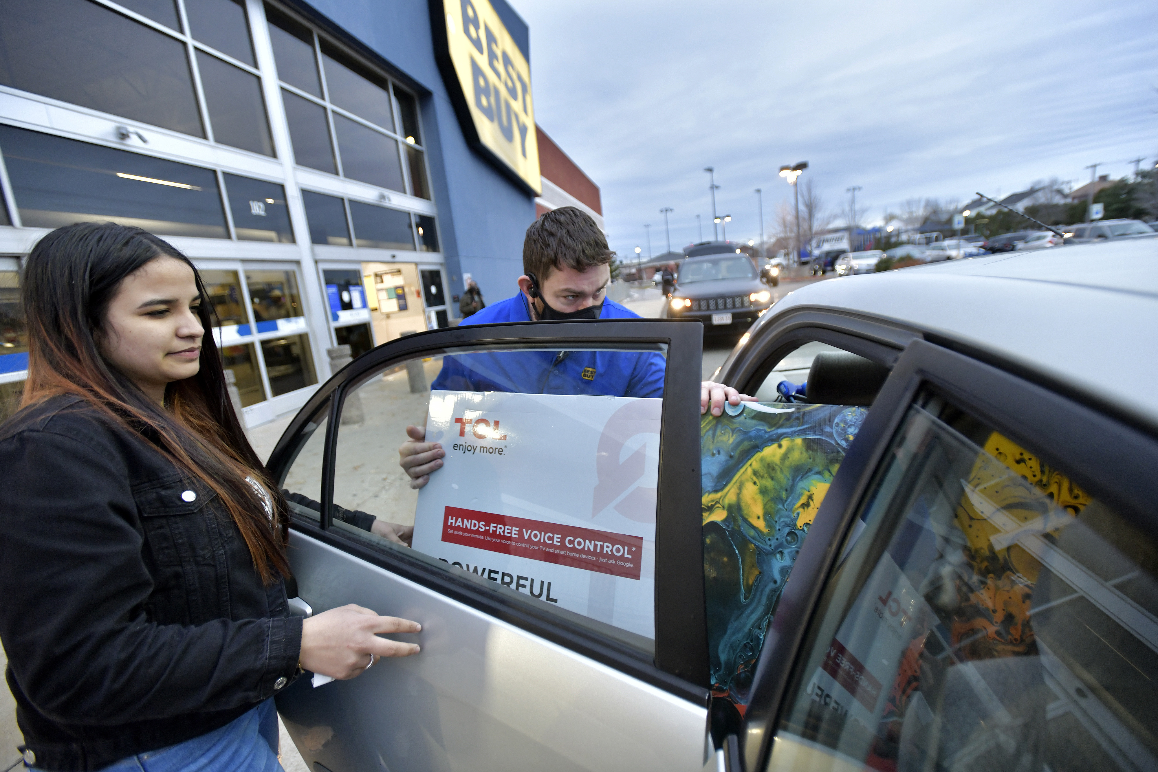 Erica Sanchez helped a Best Buy employee load a television into her car outside a Best Buy on Black Friday in Everett. 