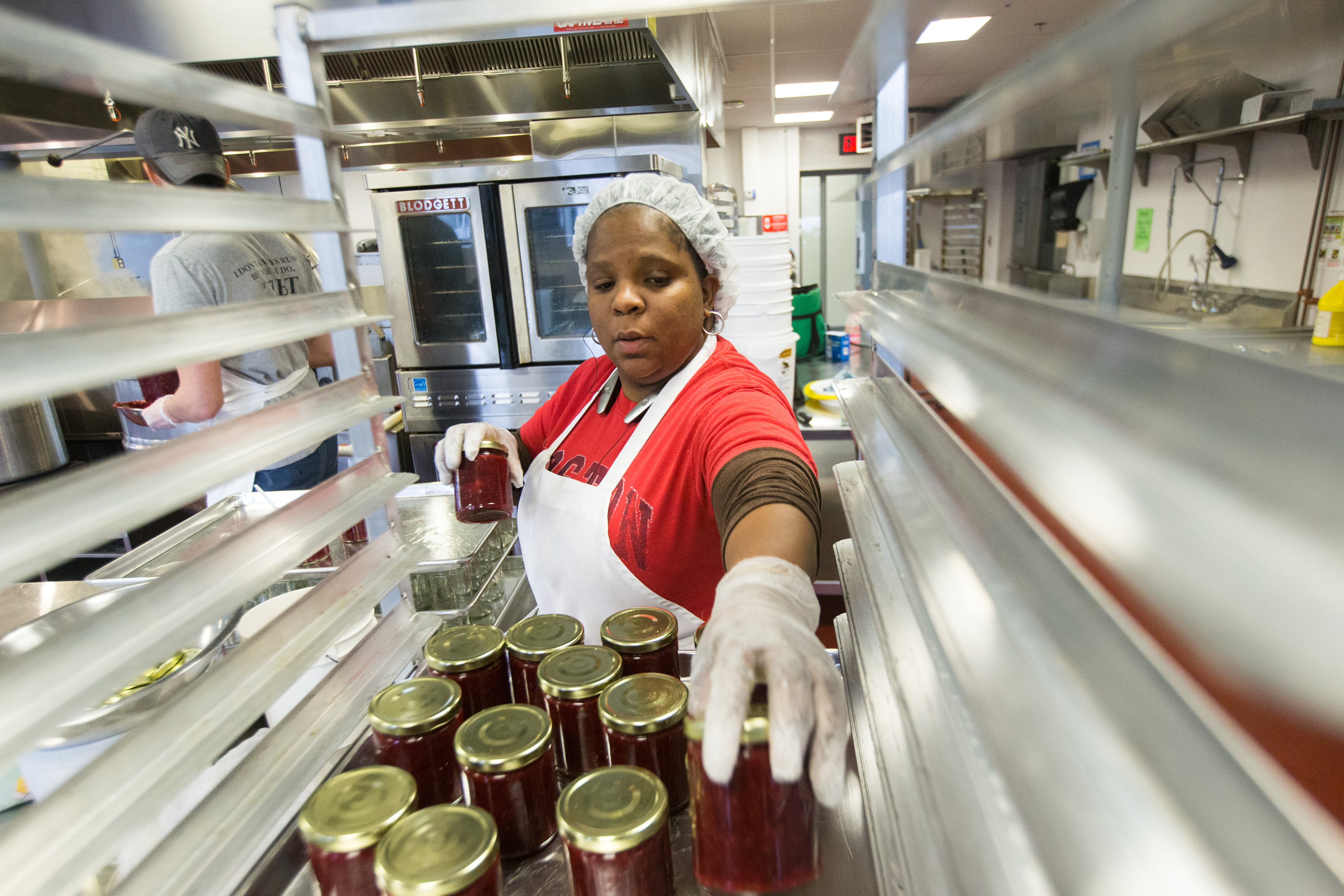 Kereen Pinnock of Deborah's Kitchen stacks jars of jam at the Commonwealth Kitchen.