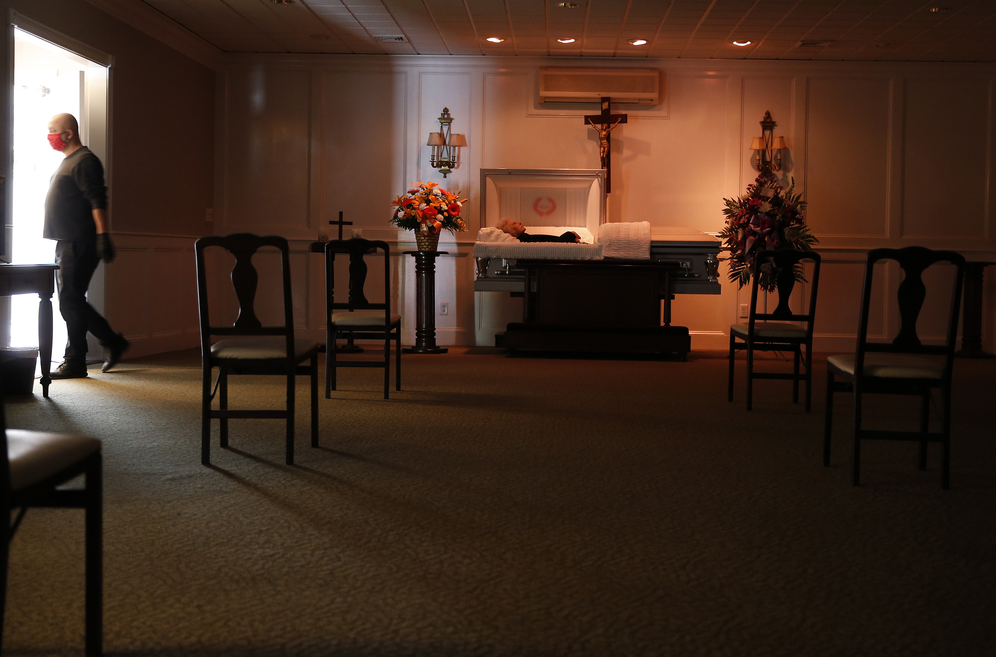 Chairs were arranged to allow for social distancing to protect against the spread of coronavirus as funeral service assistant Miguel Vargas set up for a visitation.