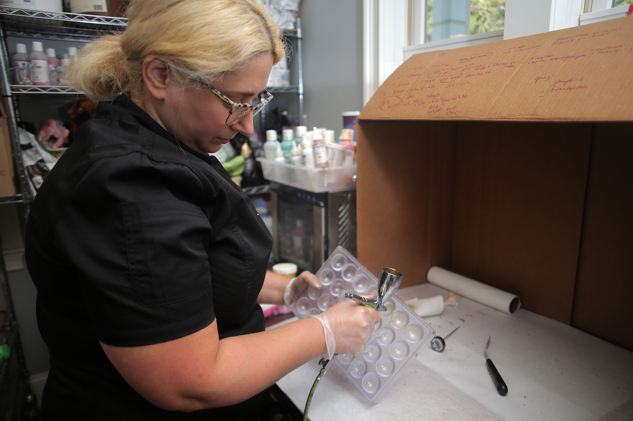 Gal uses an airbrush on a mold.