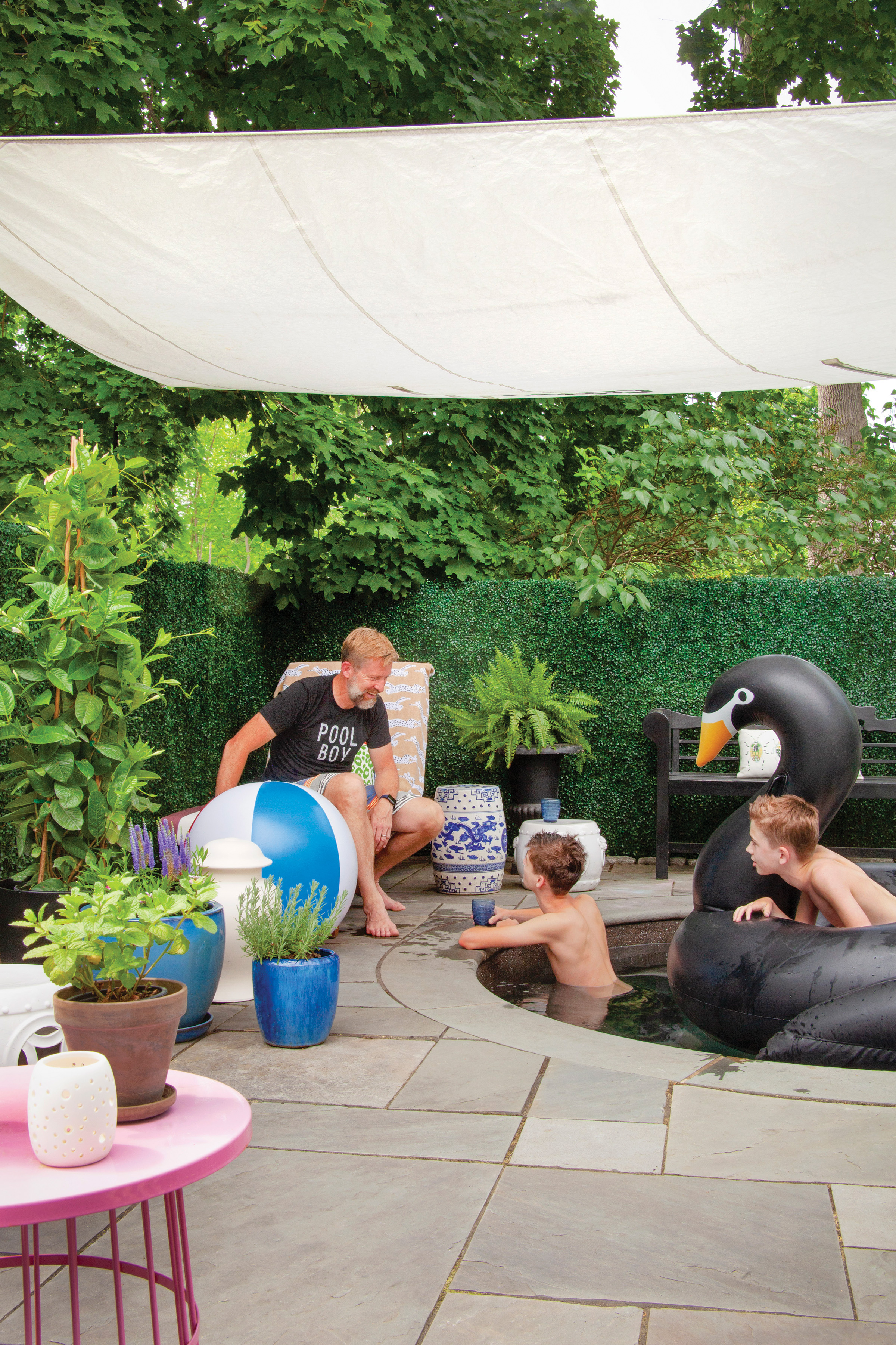 Homeowner Stephen Sheffield watches sons Milo (left) and Finley in the plunge pool. The faux hedge provides total privacy from the street and even quiets the sound of traffic.