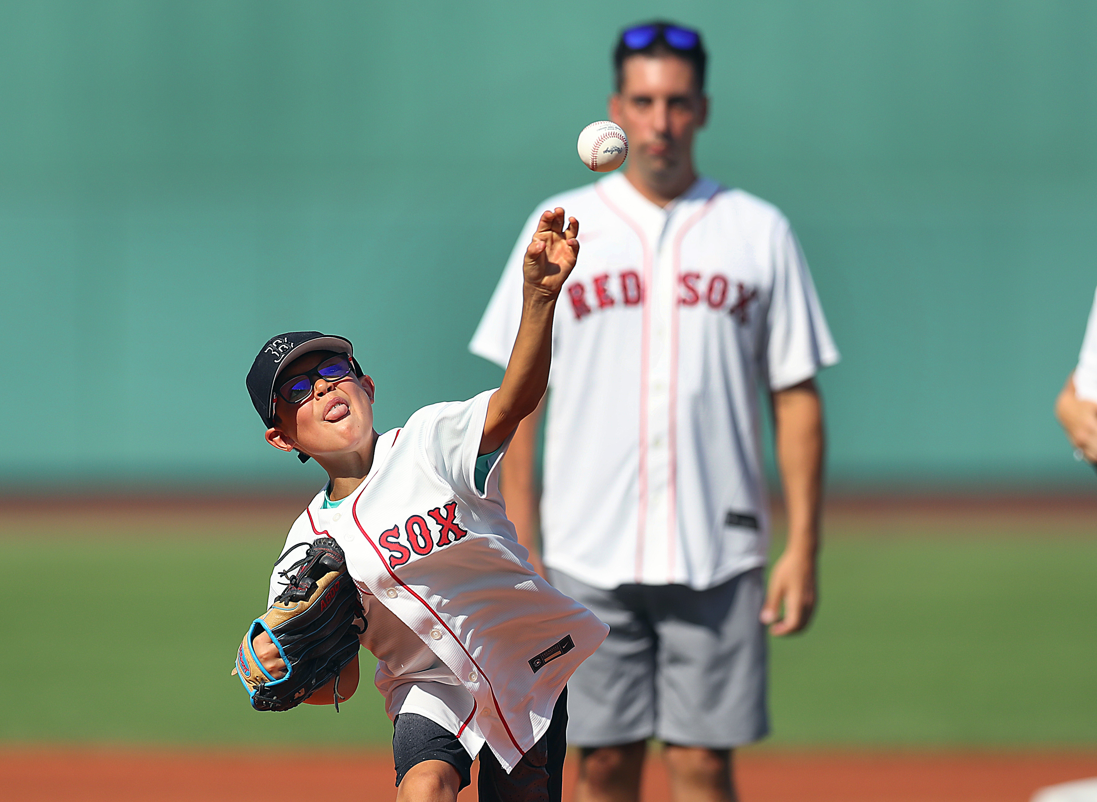 As former Globe writer Chris Snow looks on, his son Cohen fires a strike to the plate before the start of Thursday's game.