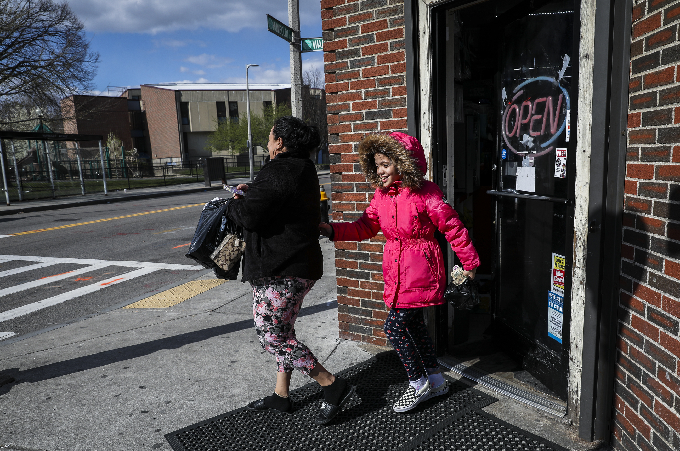 BOSTON - 4/16/2020:  Long-time customers of Claudia Market Jazmin Ochoa, left, and her daughter Ruby Pena, leave the Roxbury corner store on Thursday afternoon. As Americans reel from the impacts of the coronavirus, bodegas like Claudia Market have remained a last respite for community members. (Erin Clark/Globe Staff)