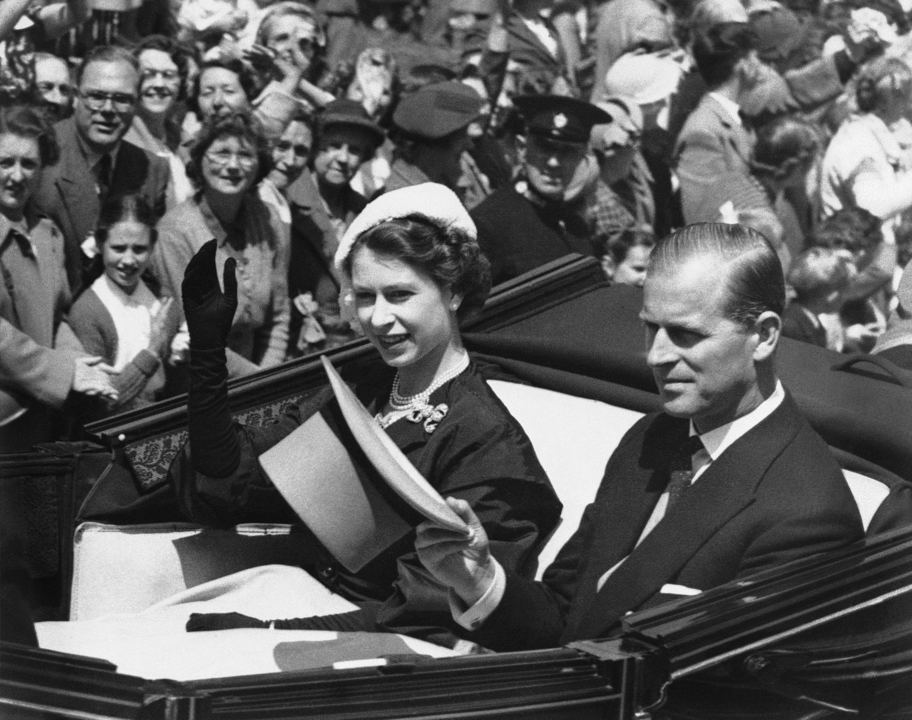 In this 1952 file photo, Britain's Queen Elizabeth II and her husband the Duke of Edinburgh travel in an open carriage at Ascot Racecourse, Ascot, England, on the second day of the Royal Ascot meeting.