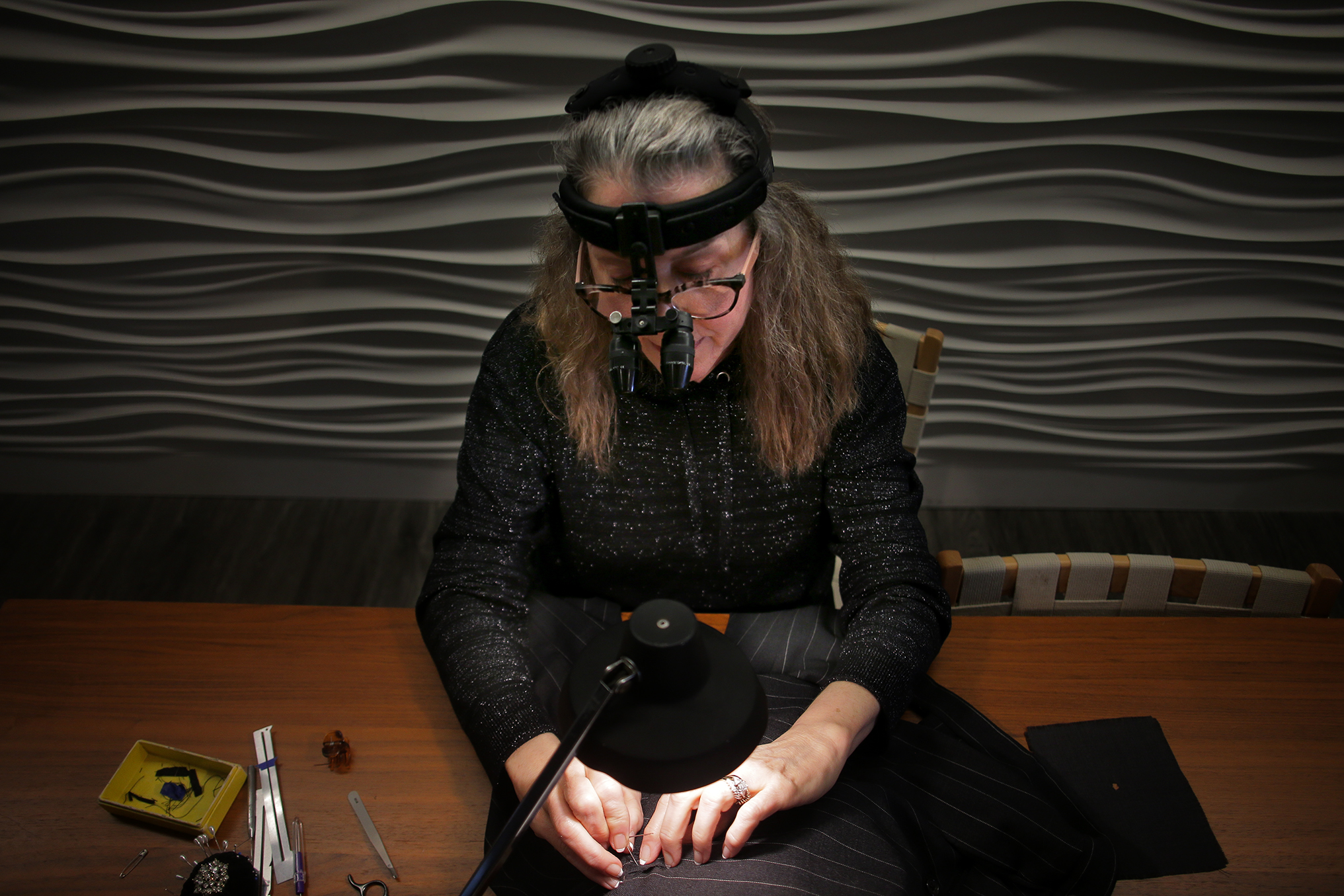 Toni Columbo reweaves moth-damaged wool clothing. With a surgeon’s loupe to magnify her work, she weaves whatever wool pattern a garment has to produce seamless, invisible repairs.