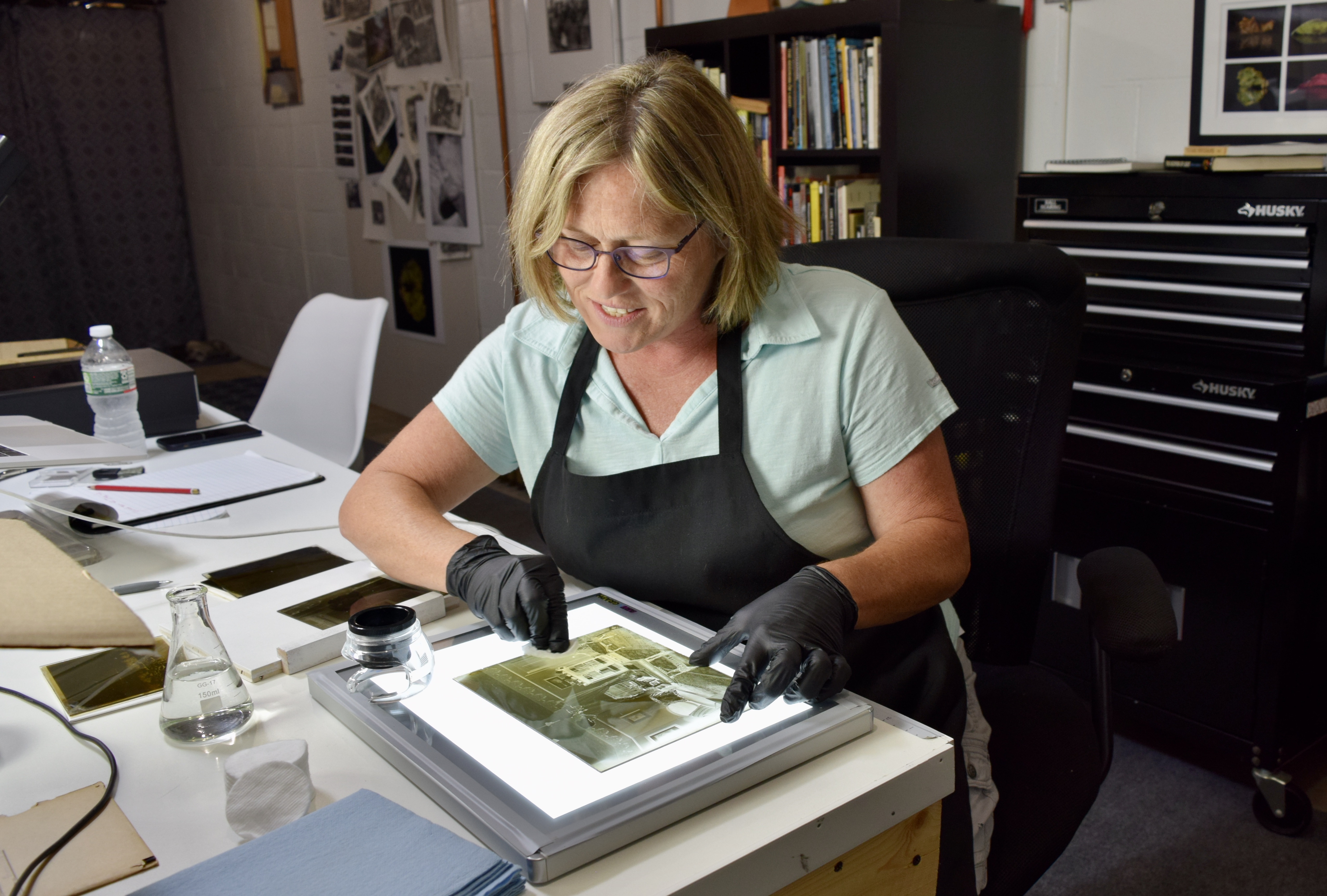 Photographer Terri Sevene Cappucci carefully cleaned a glass plate negative from the late 1800s in her Turners Falls studio.