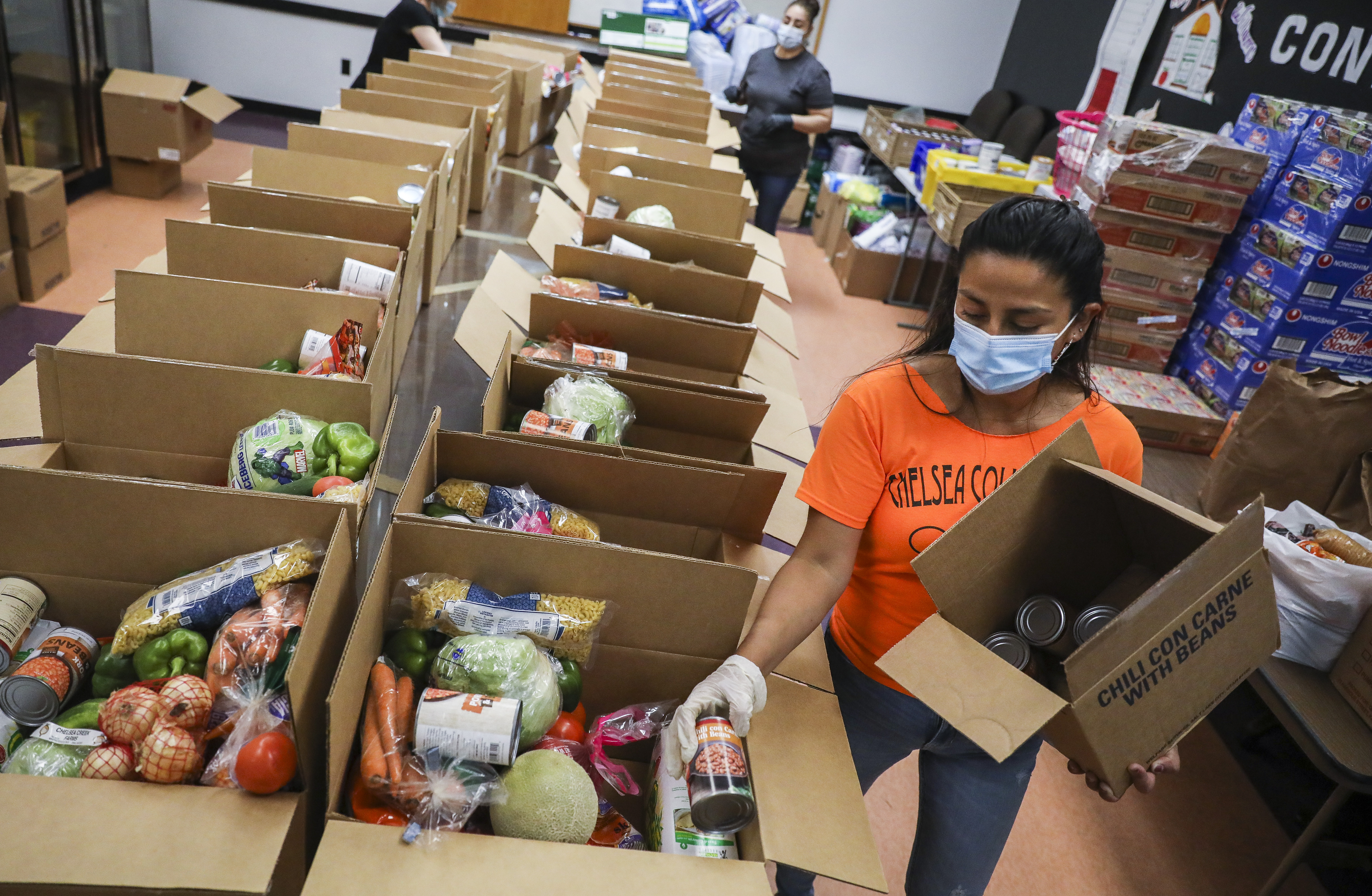 Cinthya Torres placed canned goods into boxes at the Chelsea Collaborative.