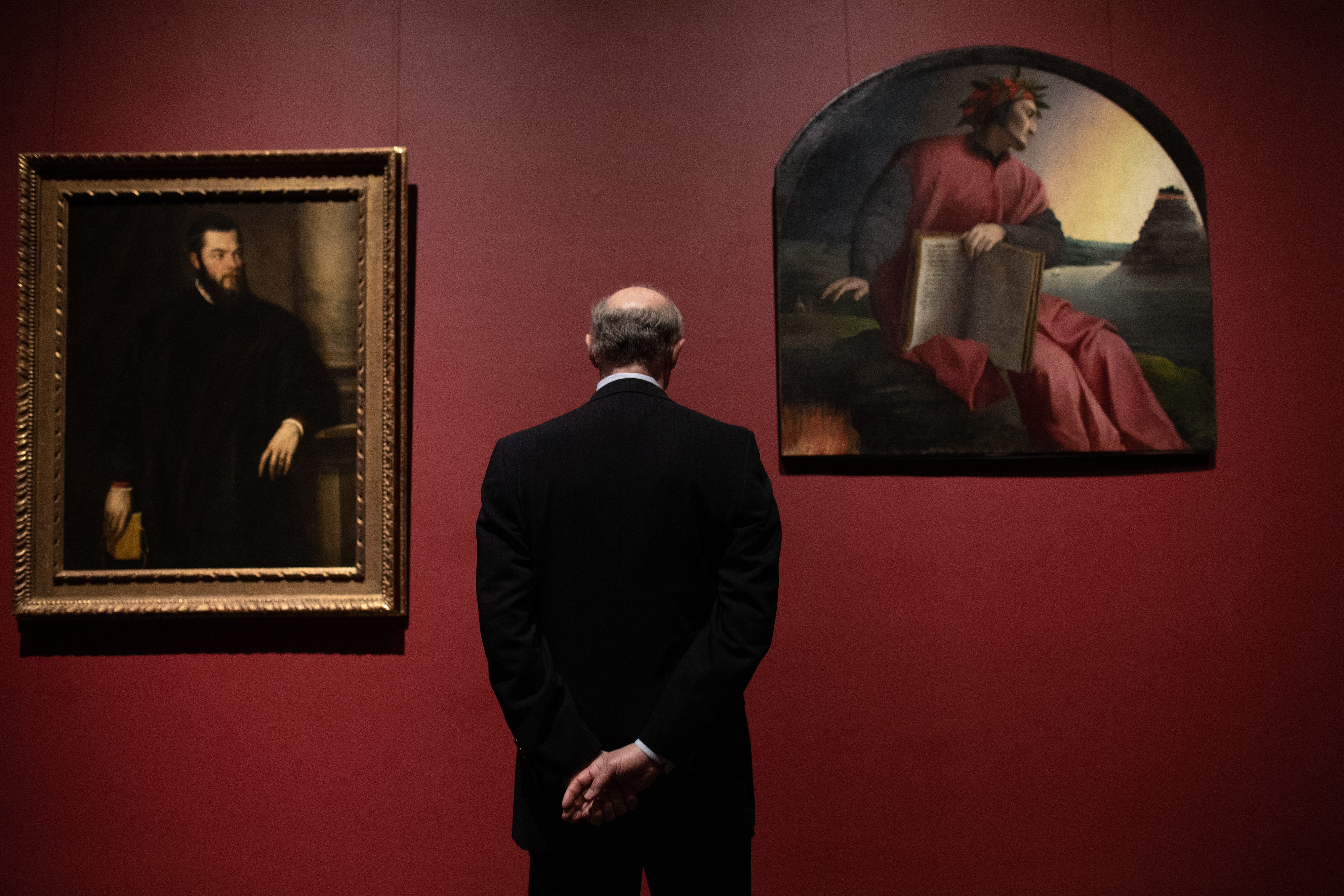 A visitor studies Titian's portrait, "Benedetto Varchi" (left) and Bronzino's "Allegorical Portrait of Dante," at the Metropolitan Museum of Art in June.